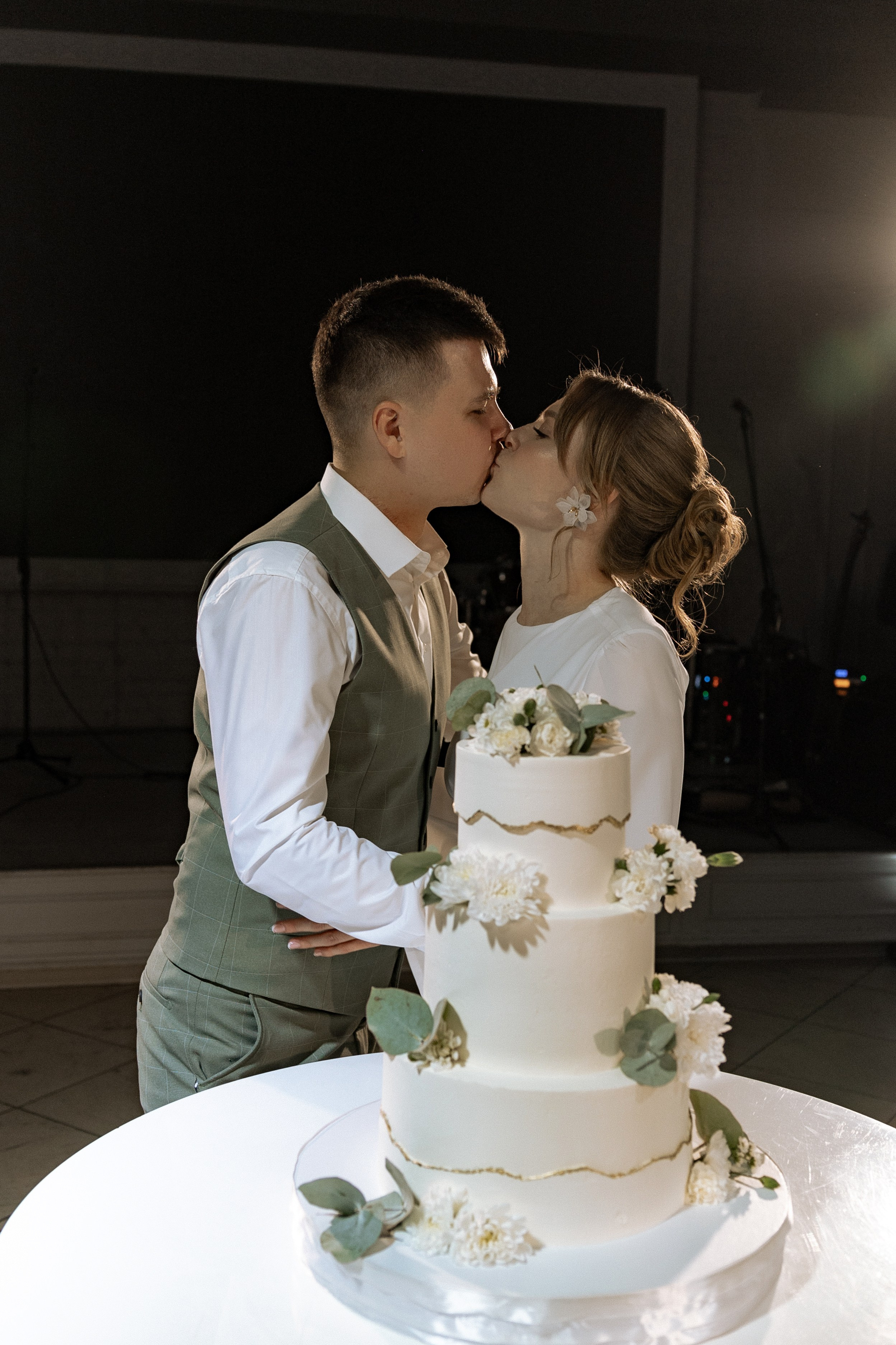 Жениха и невеста целуются на фоне трехъярусного торта, кондитер Красноярск, организация свадьбы