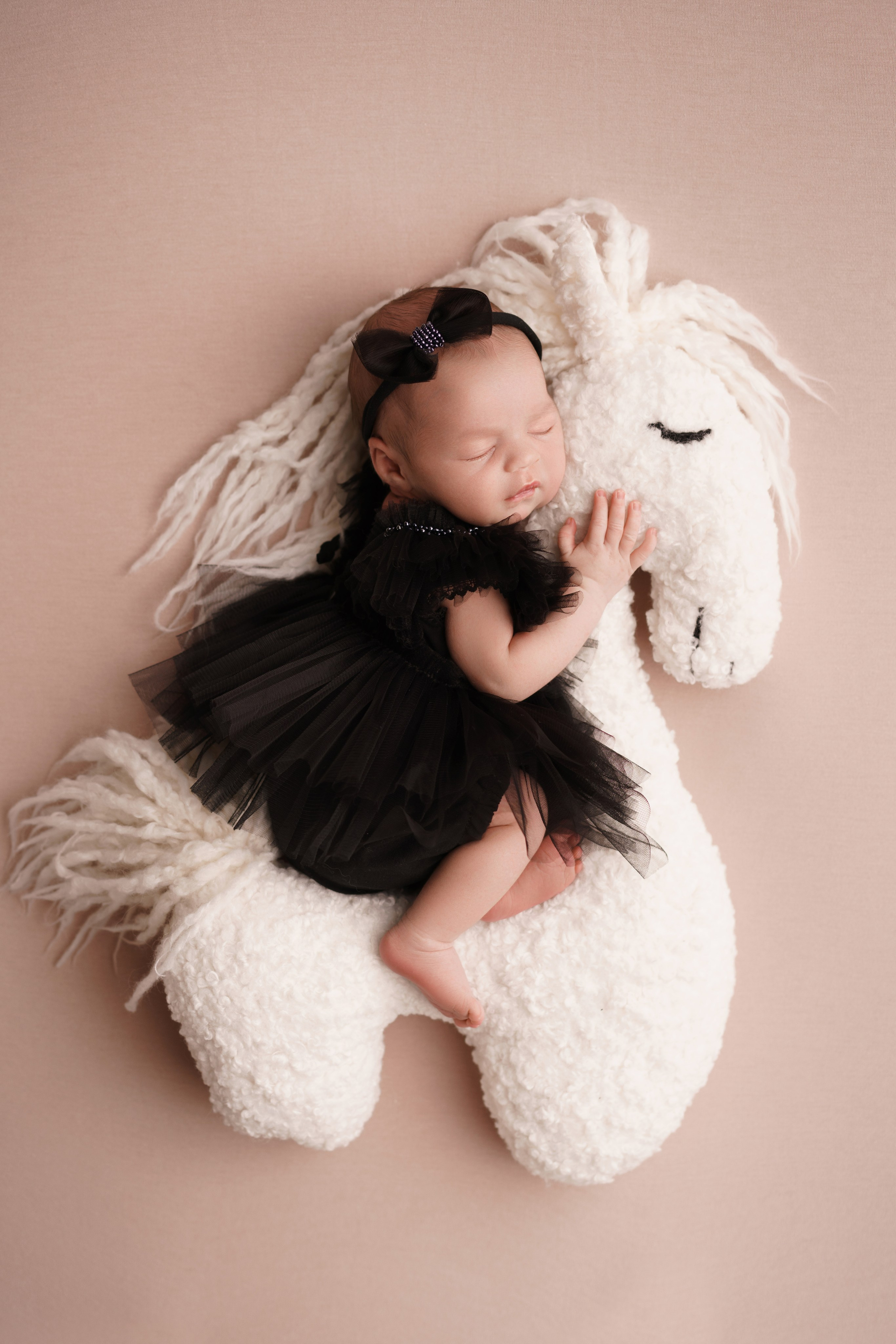 Девочка на игрушечной лошадке - Детская фотосессия в стиле newborn