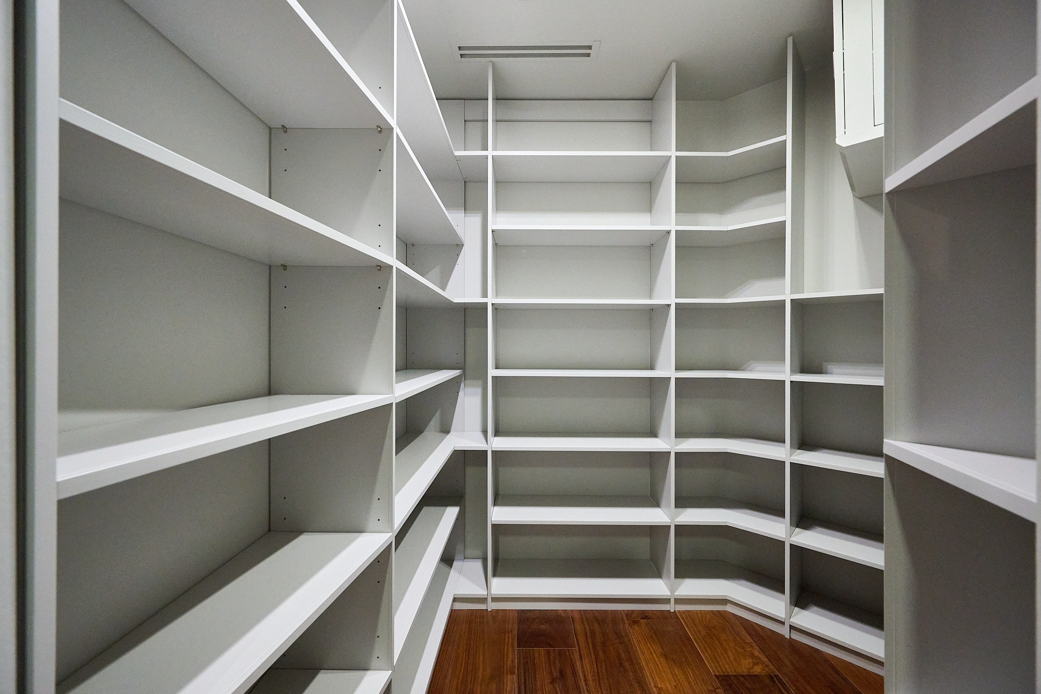 гардеробная с белыми полками и белыми стенами 