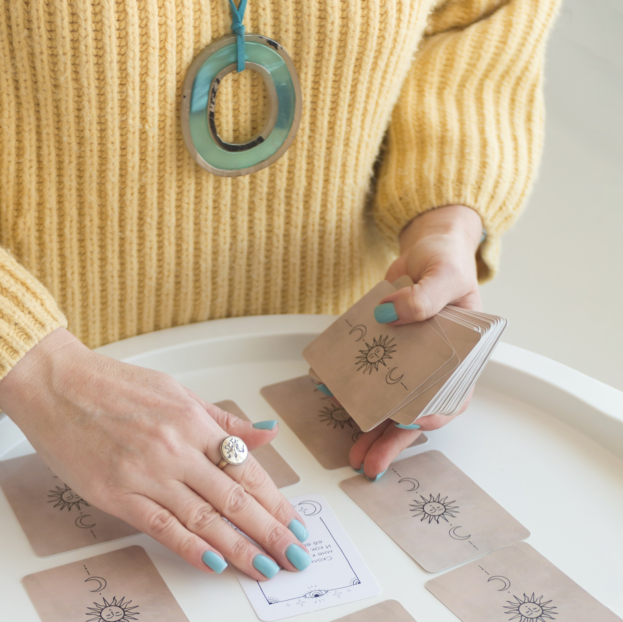 Астролог раскладывает карты на столе. Руки крупным планом. Астрологические консультации в Хабаровске.