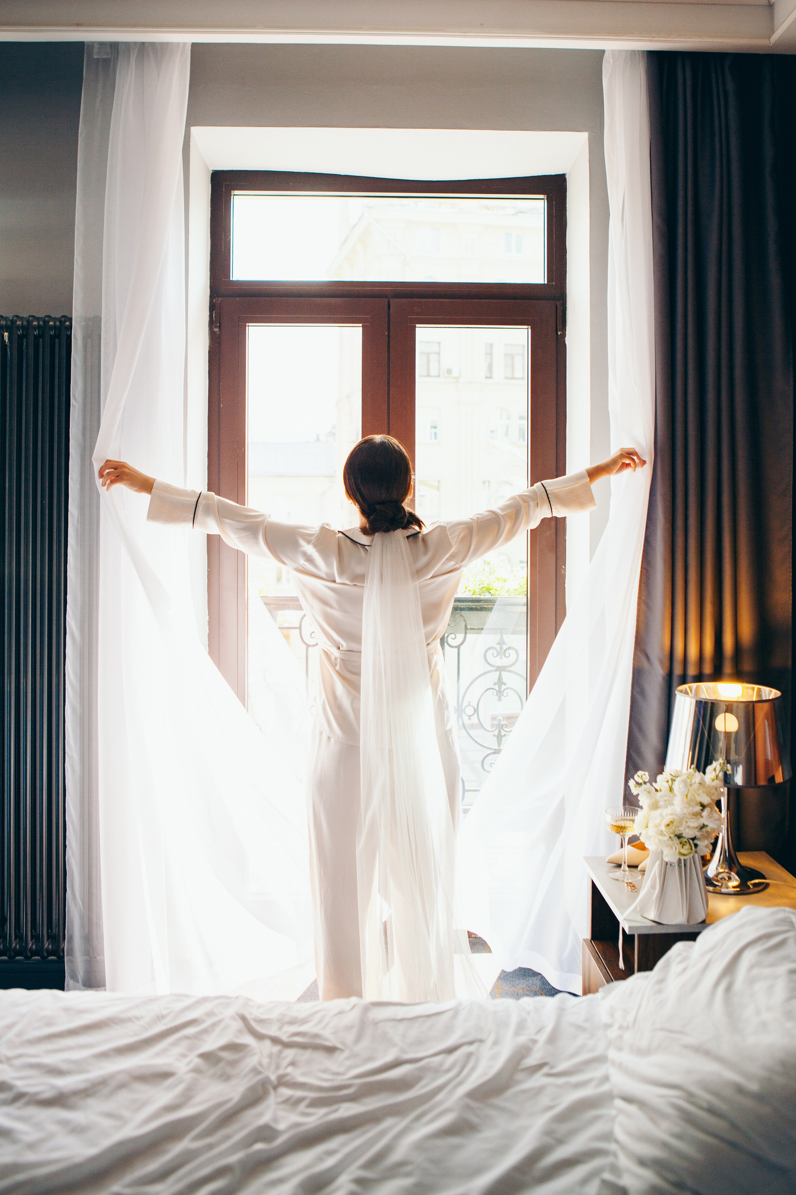 невеста раскрывает шторы и открывает окна