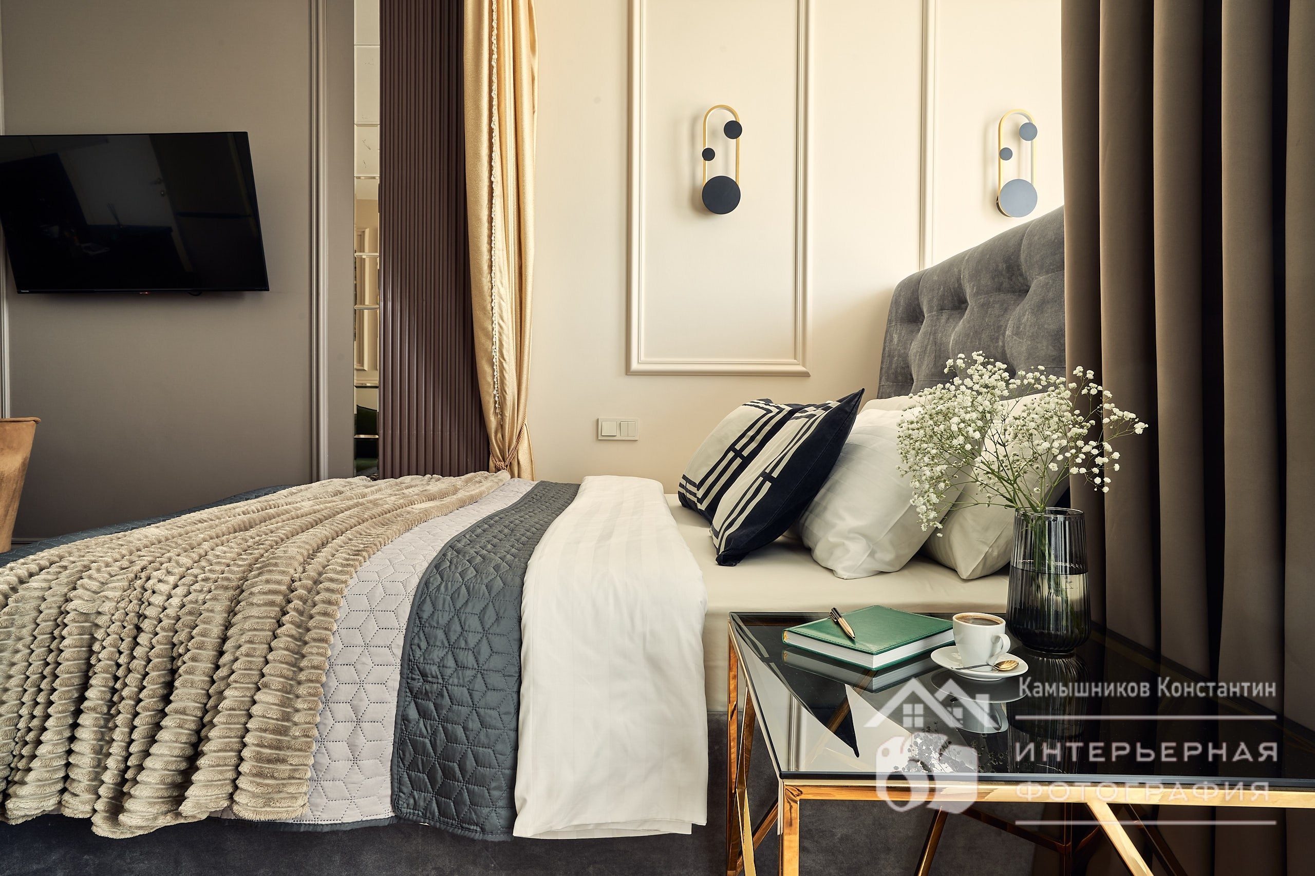 Интерьерная фотография апартаментом на Ходынском бульваре: двуспальная кровать сквозь букет полевых цветов