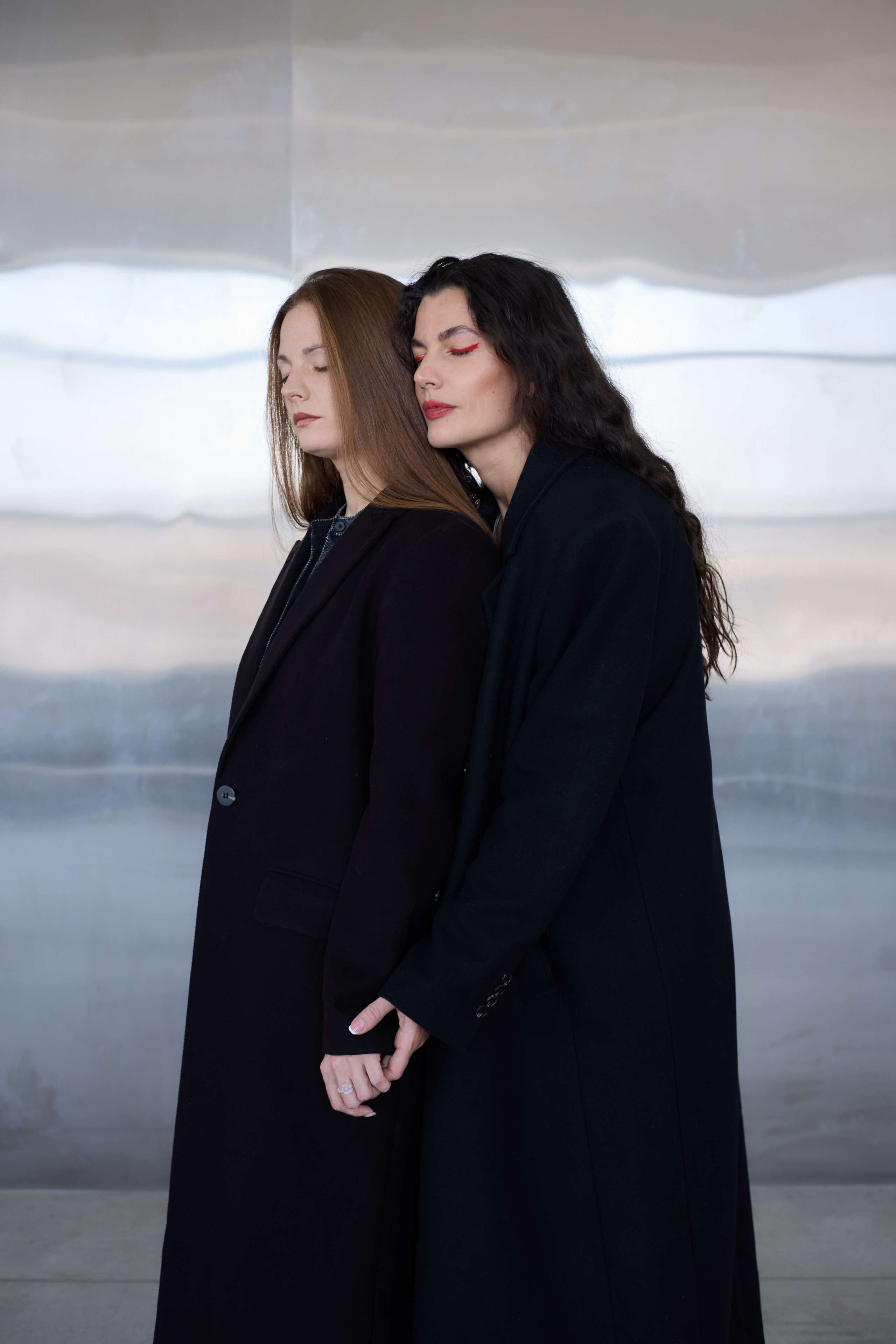 Две девушки на фоне металлической стены взявшись за руки. Виктория Брызгалова и Анна Пижонкова