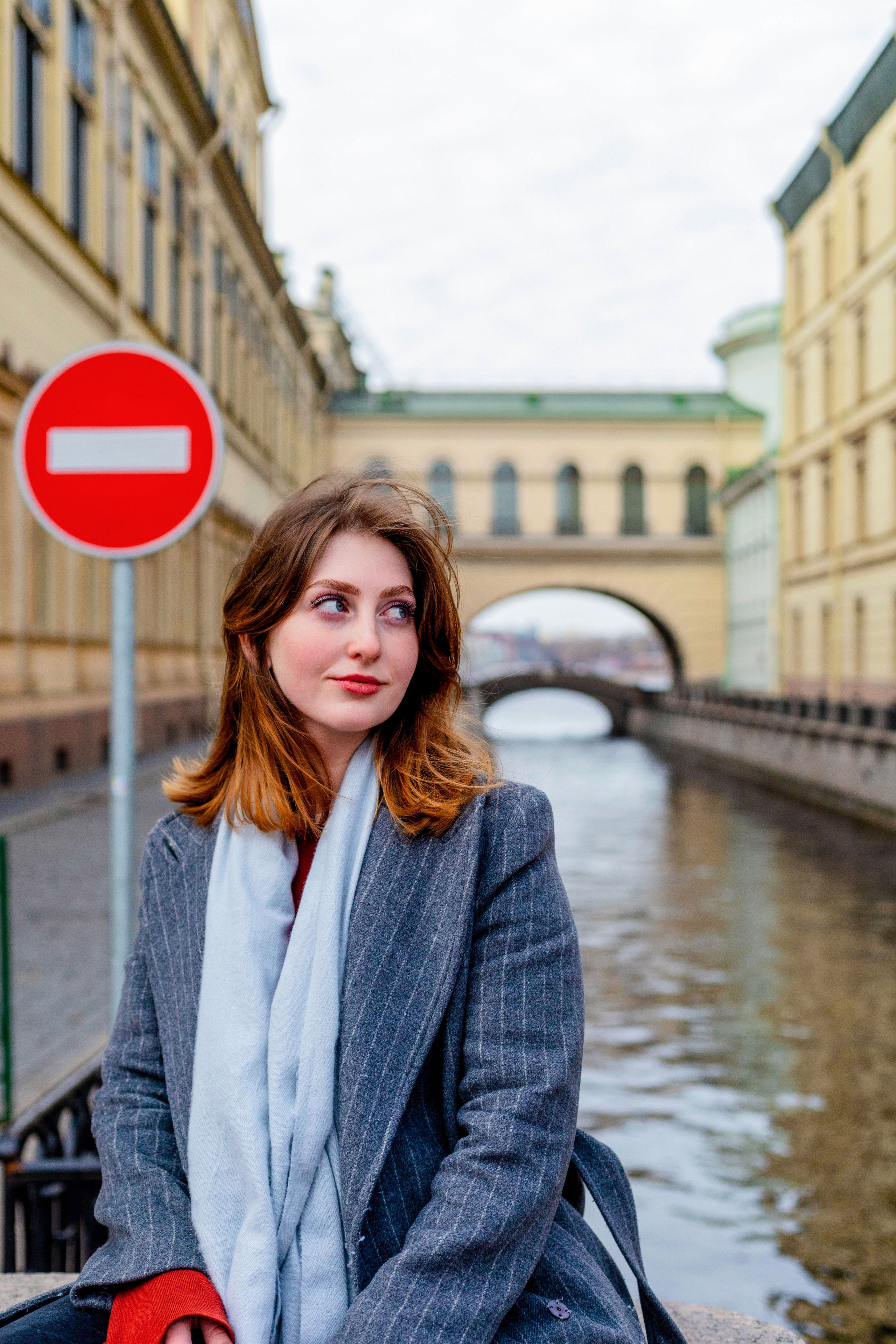 Женская портретная фотосессия на Эрмитажном мостике через Зимнюю канавку — крупный план с видом на исторический центр
