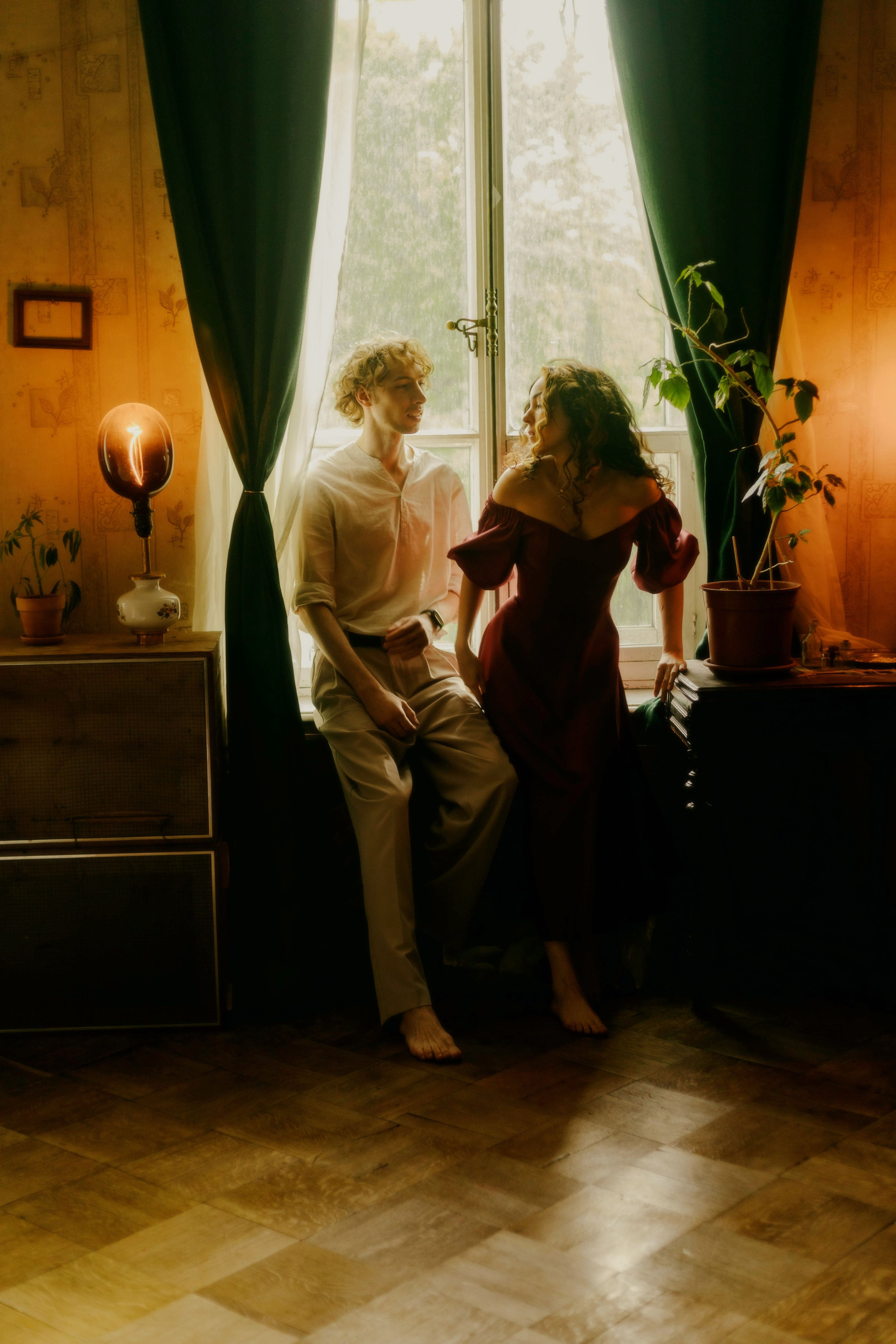 Студийная love story в Санкт-Петербурге, винтажная квартира,пара стоит возле окна и смотрит друг на друга