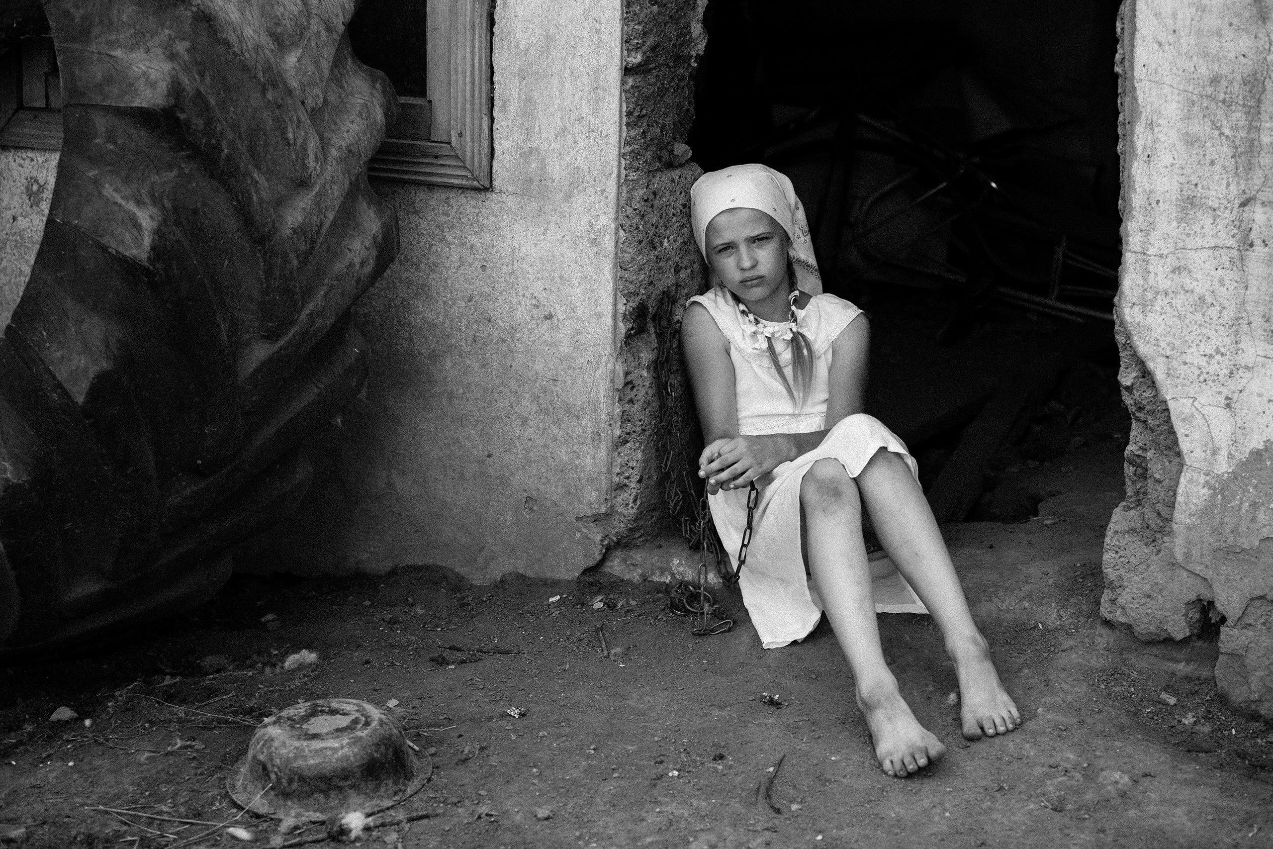 Девочка двери бани в деревне, потерявшая нового друга -собаку, грустит и печалится.