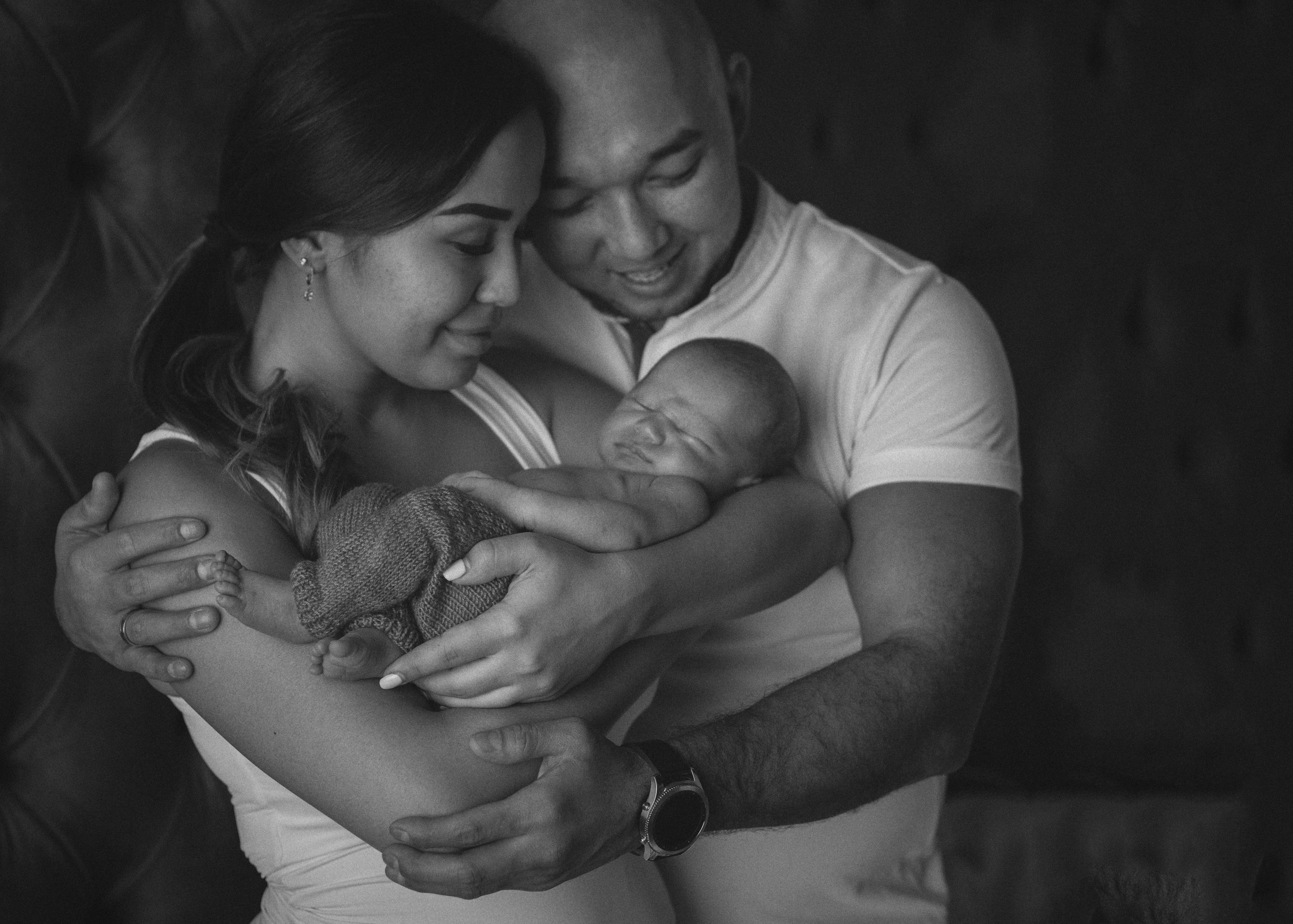 Семья. Портрет малыша на руках папы и мамы у окна.