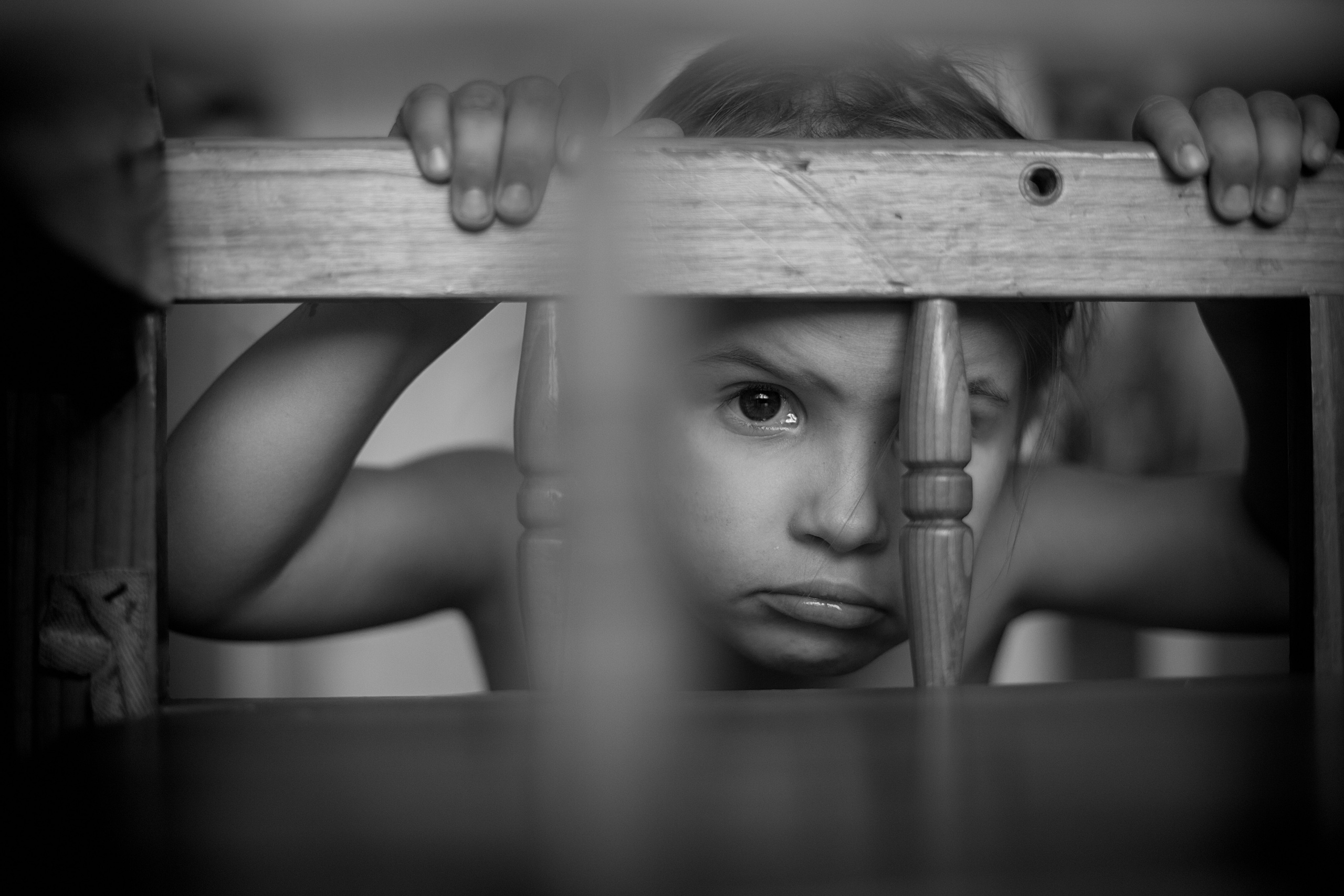 Девочка смотрит через стульчик, портрет.