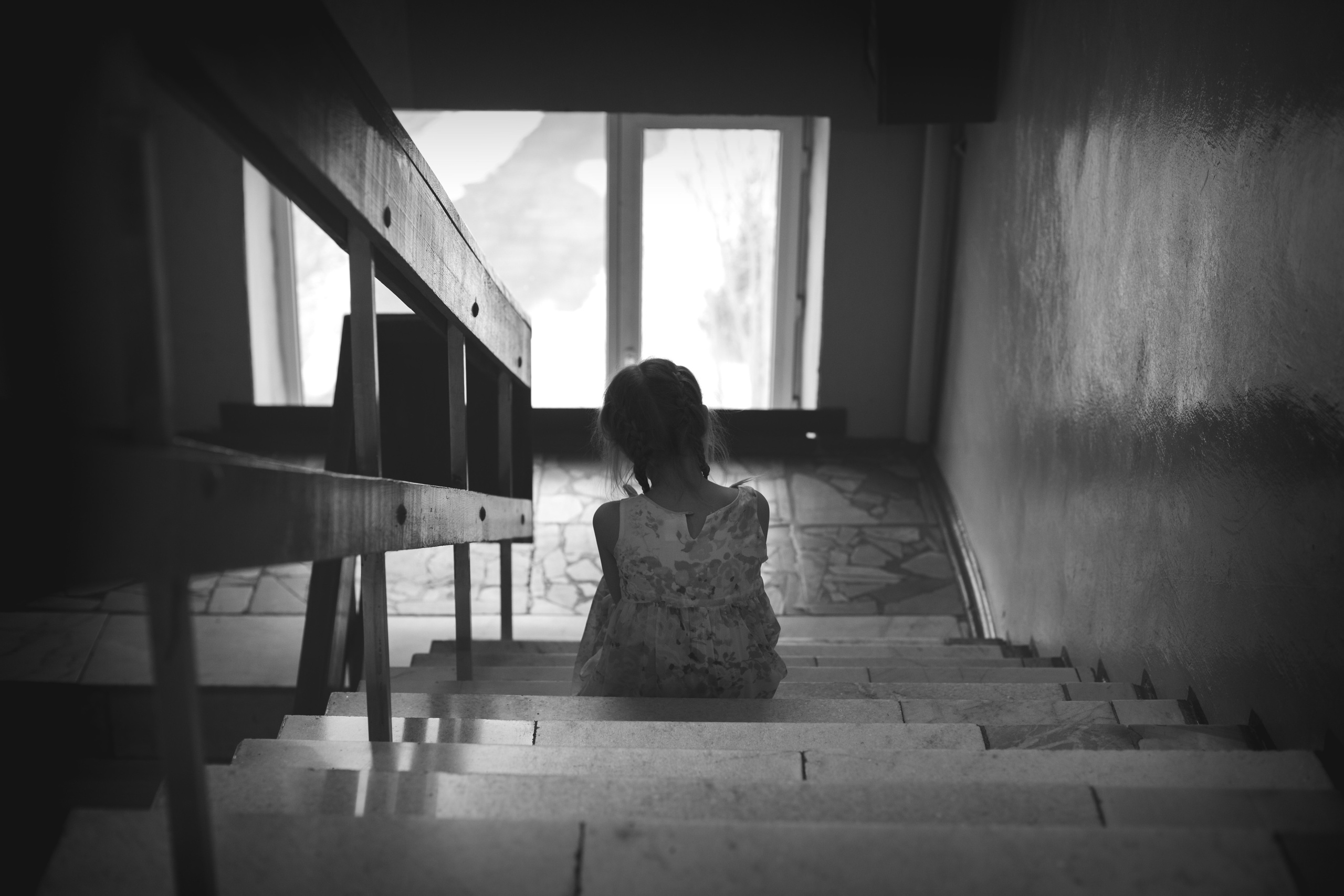 Грустная девочка сидит на лестнице у мамы на работе, в ожидании любимой мамы.