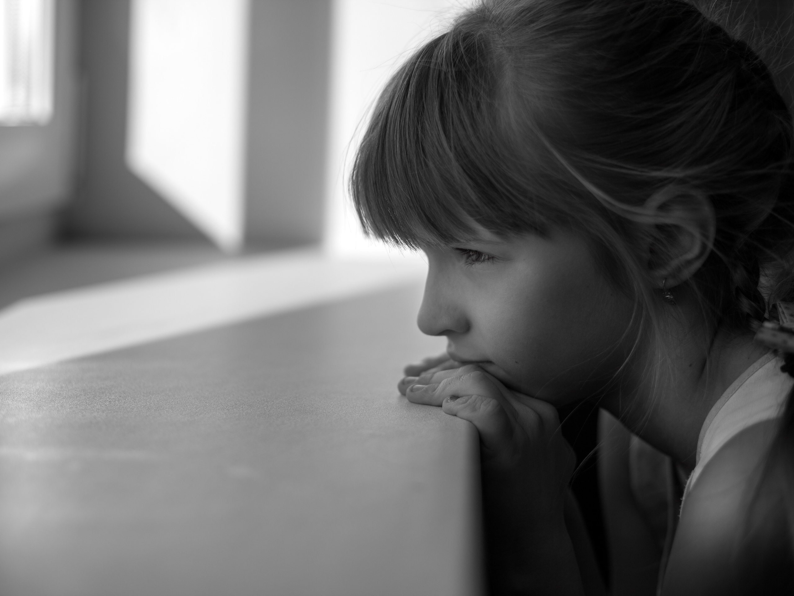 Грустная девочка смотрит в окно, портрет.