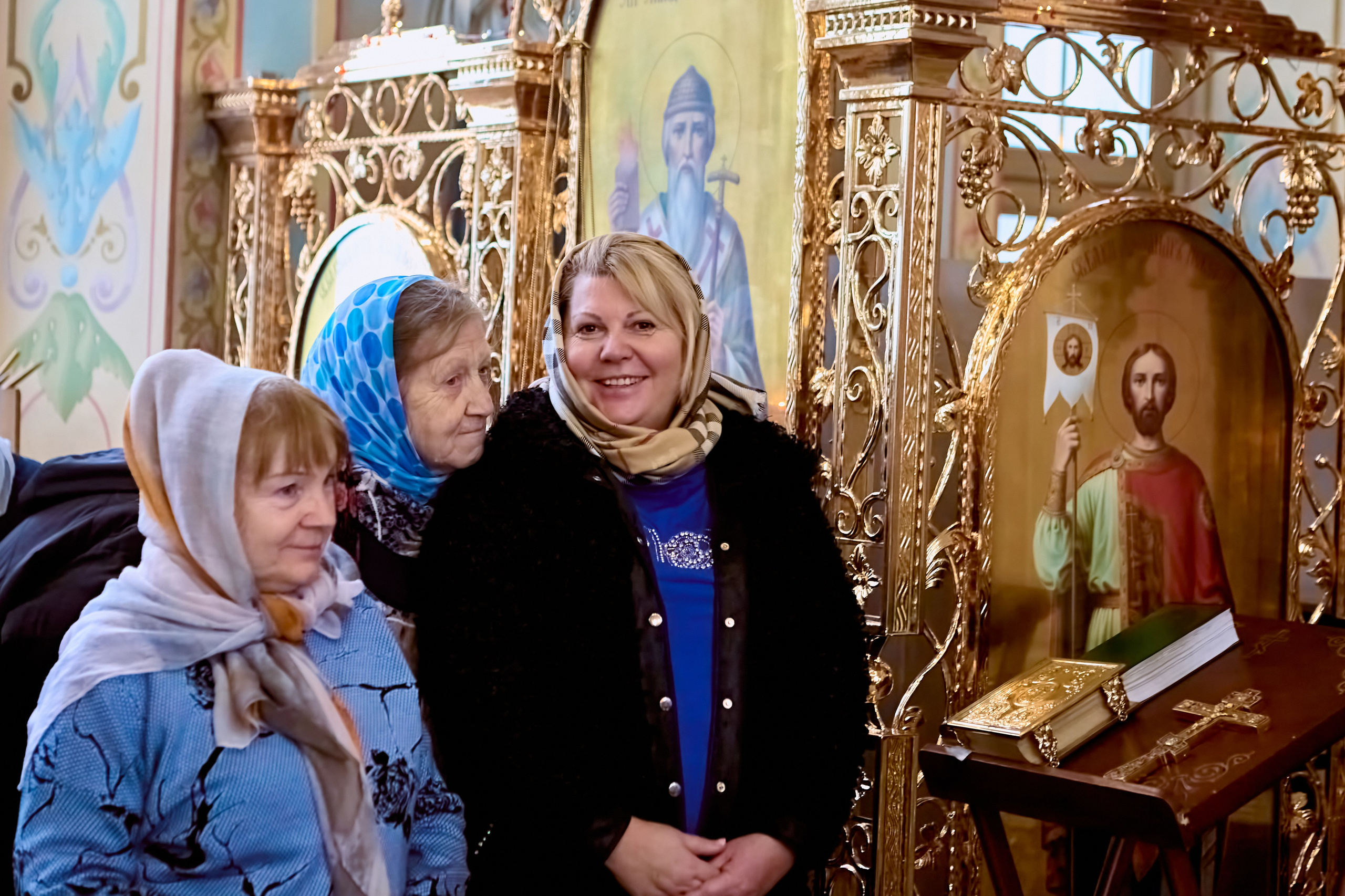 Прихожане в троем стоят и смотрят на причастие