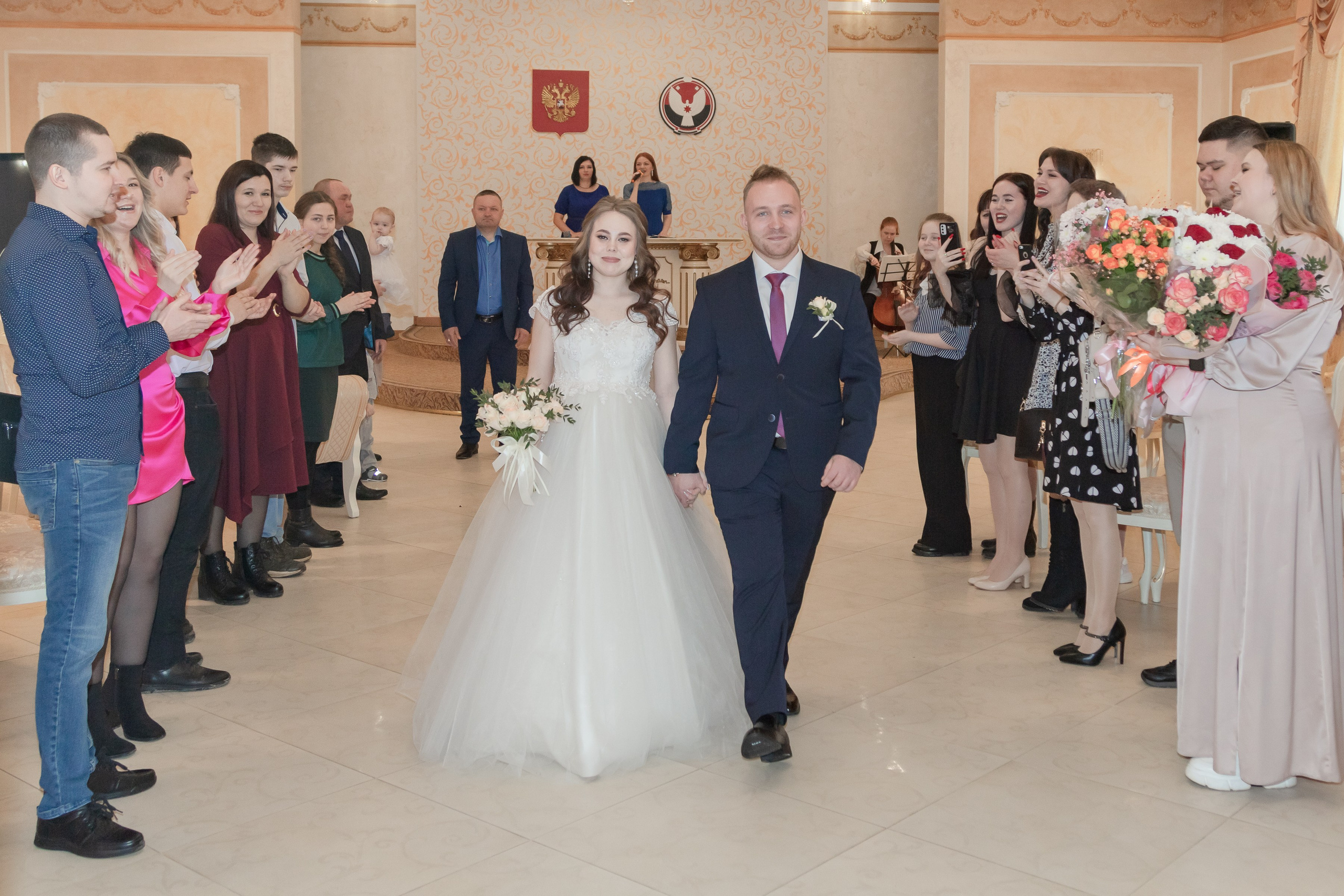Жених и невеста выходят из зала