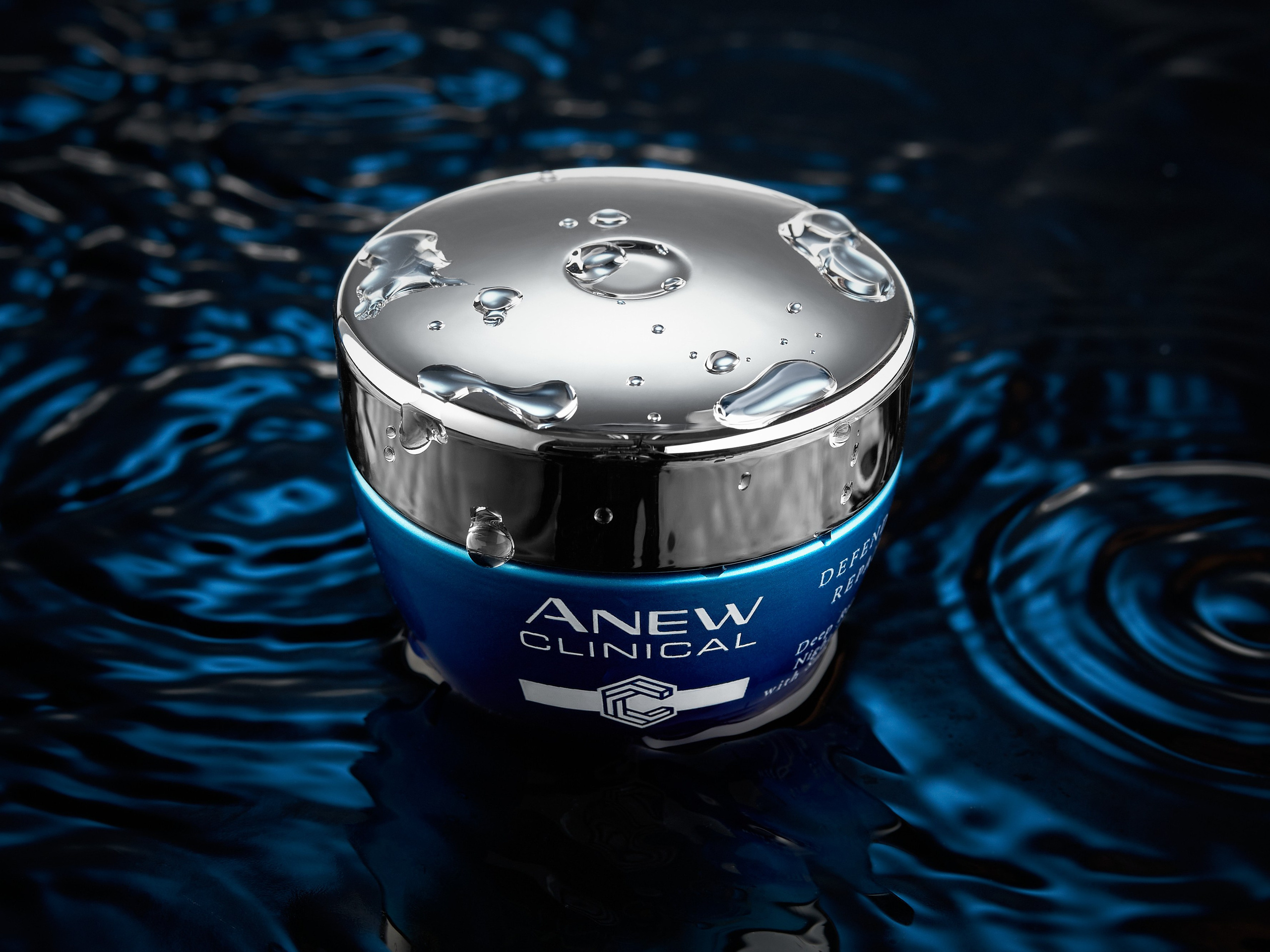 Крем в круглой банке Anew на фоне с бликами воды