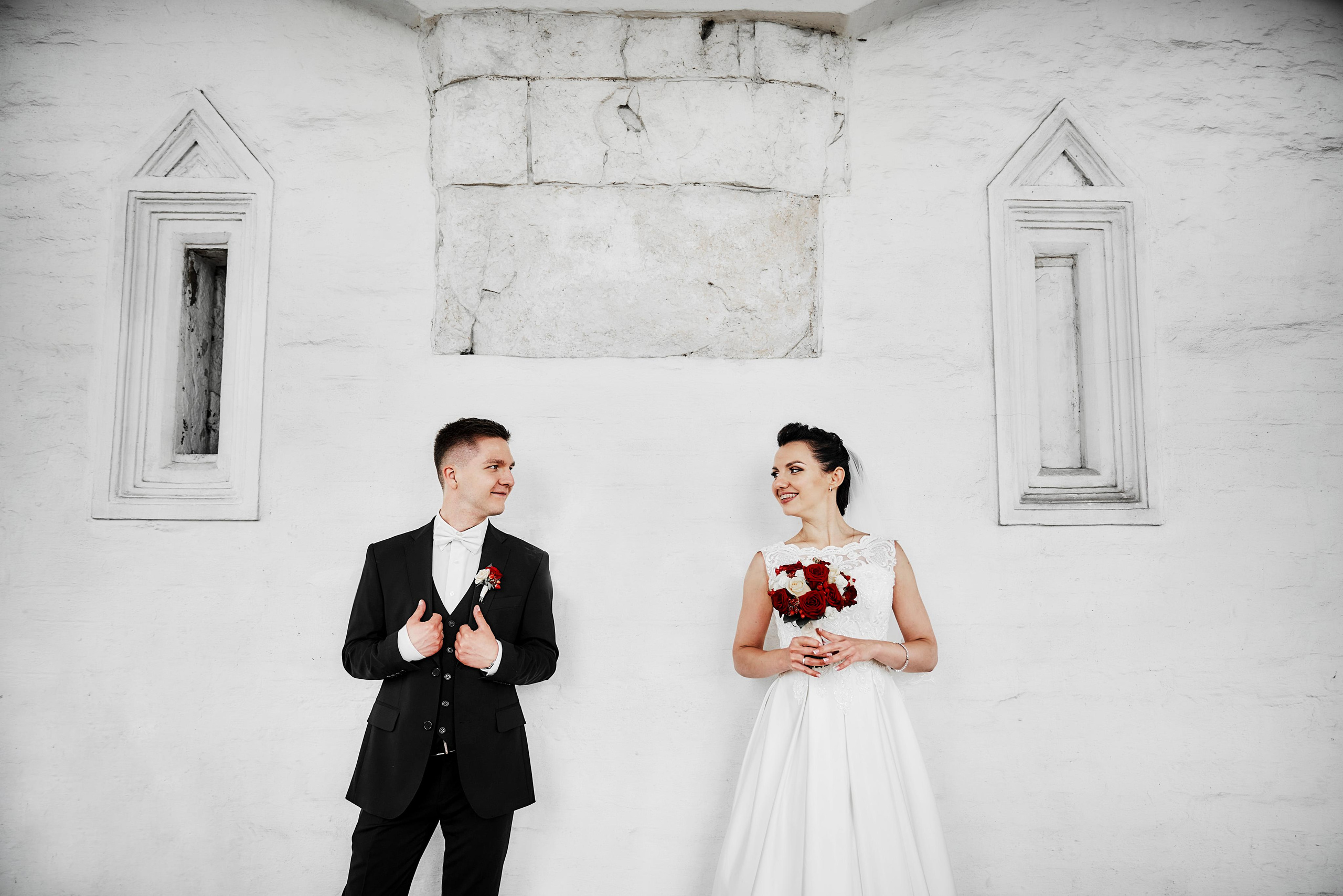 жених и невеста у белой стены