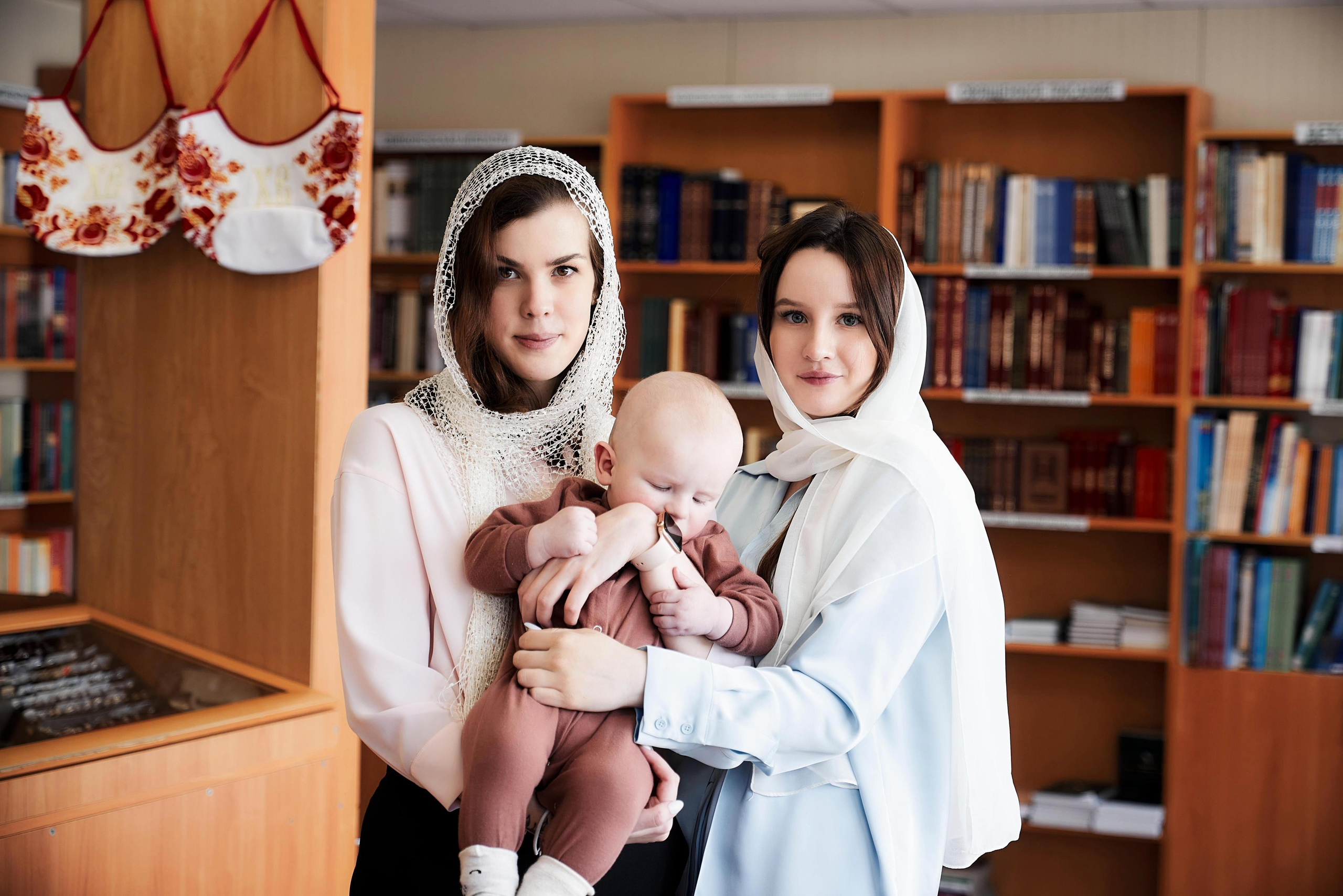 в церковной лавке мама держит ребёнка перед крестинами