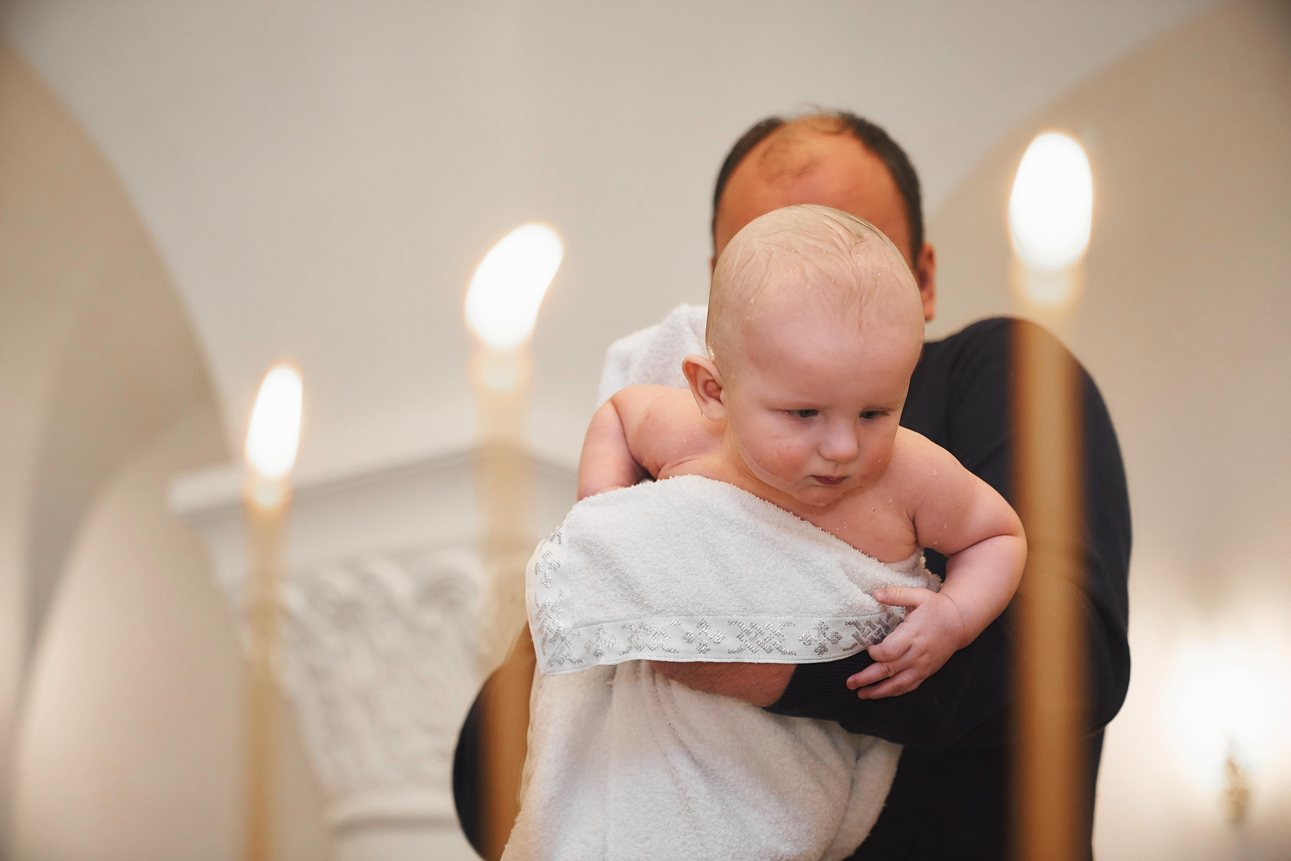 маленький мальчик на руках у крёстного отца в храме Сергия Радонежского в Солнцево