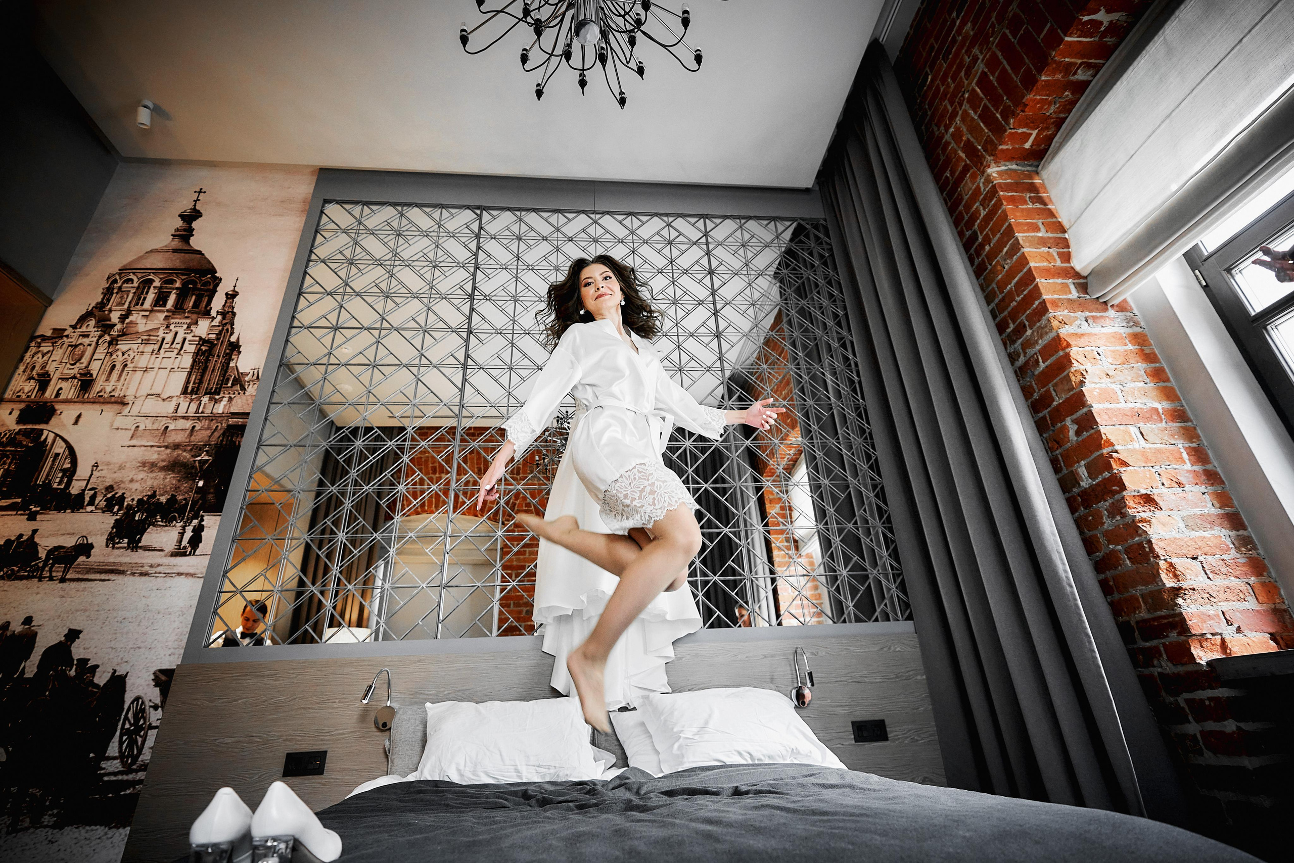 девушка прыгает на кровати в отеле PR Myasnitsky