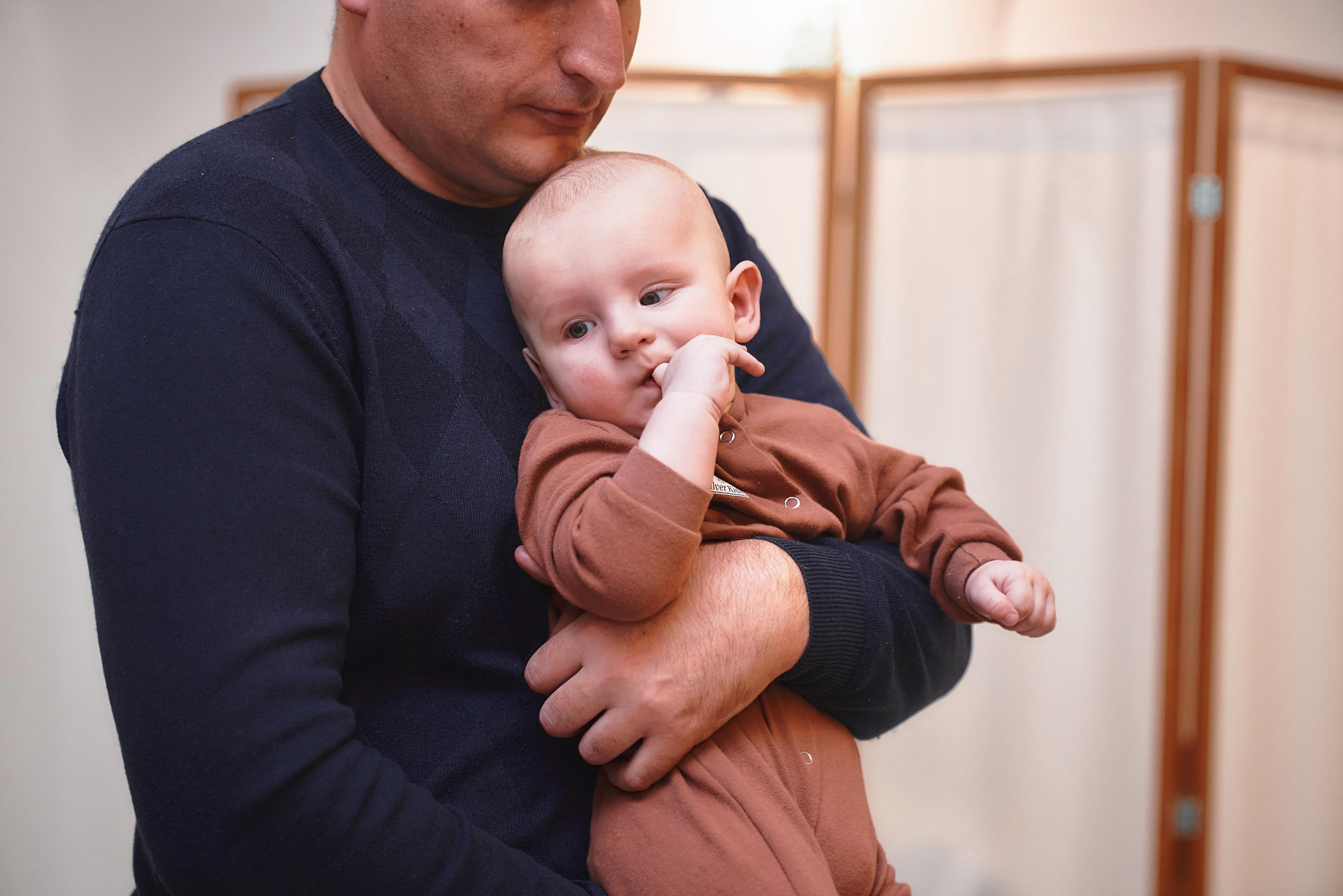 Ребёнок на руках крёстного отца в церкви