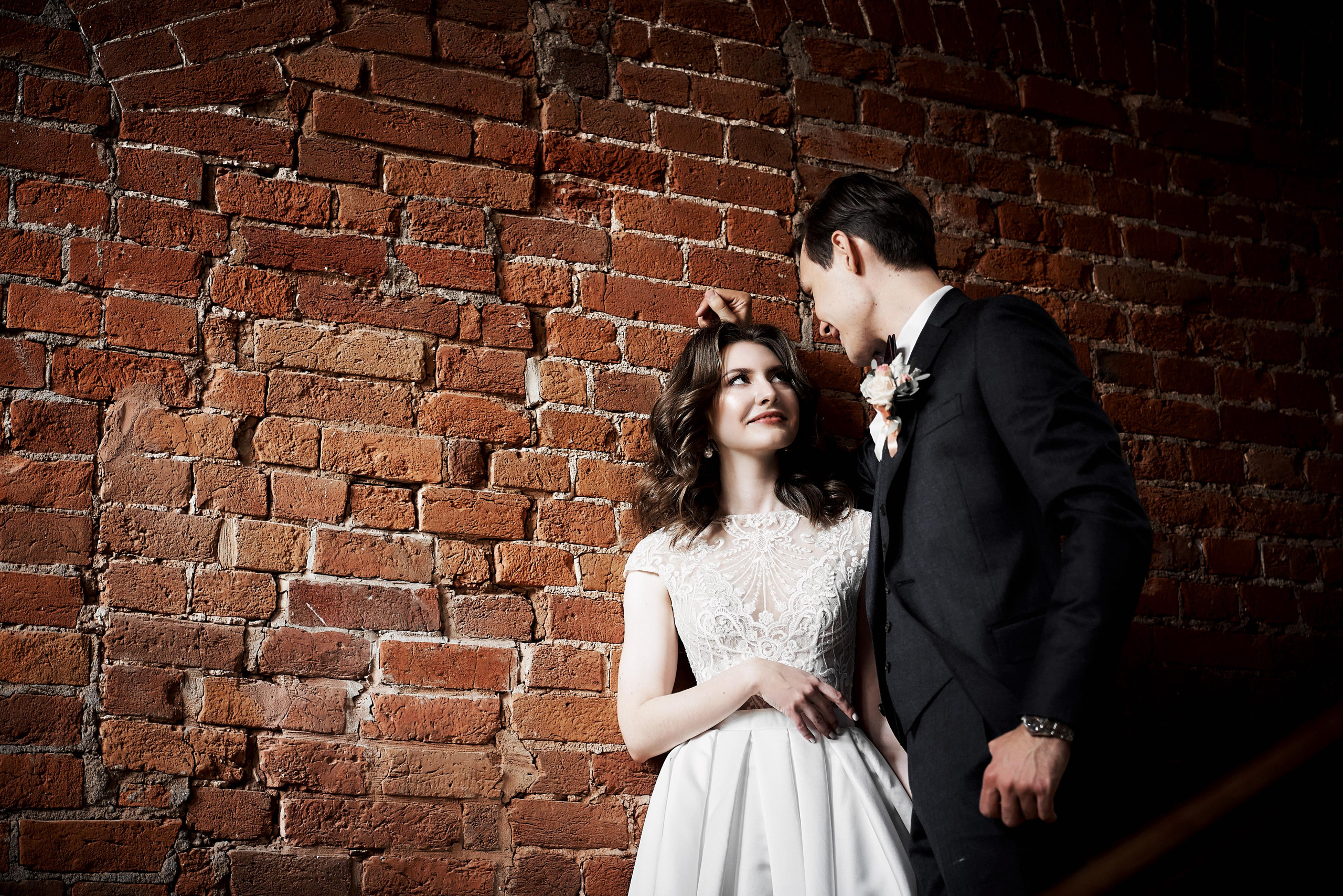 жених и невеста у красной кирпичной стены