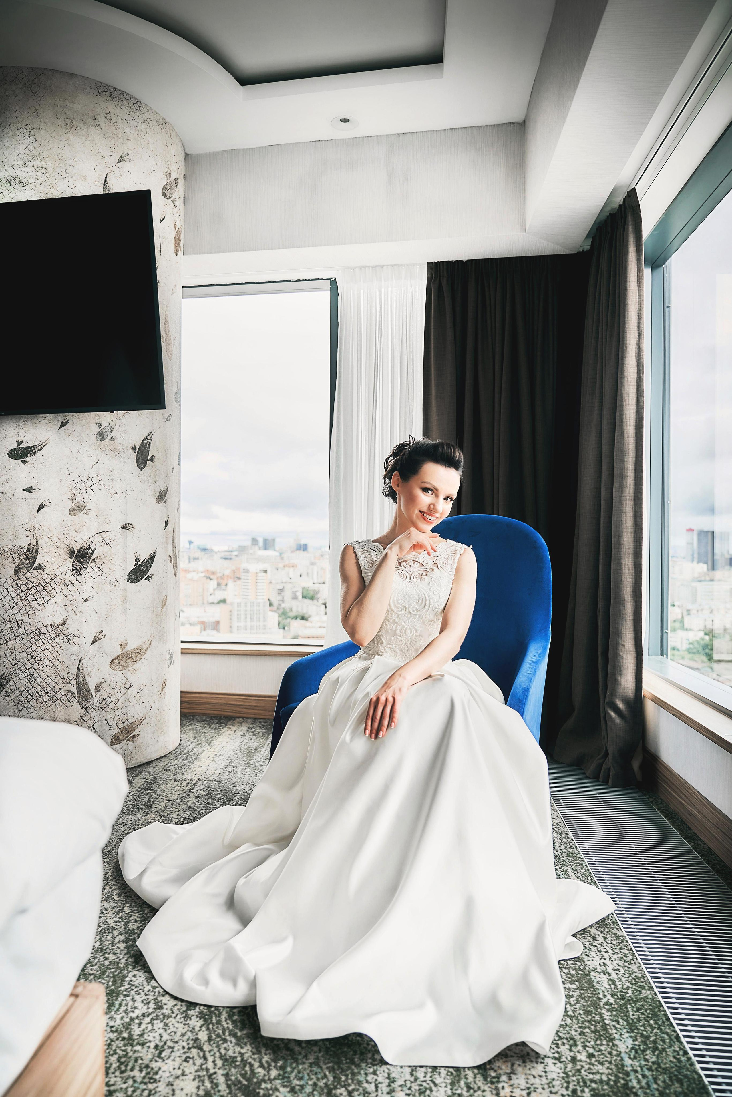 Девушка в свадебном платье на стуле