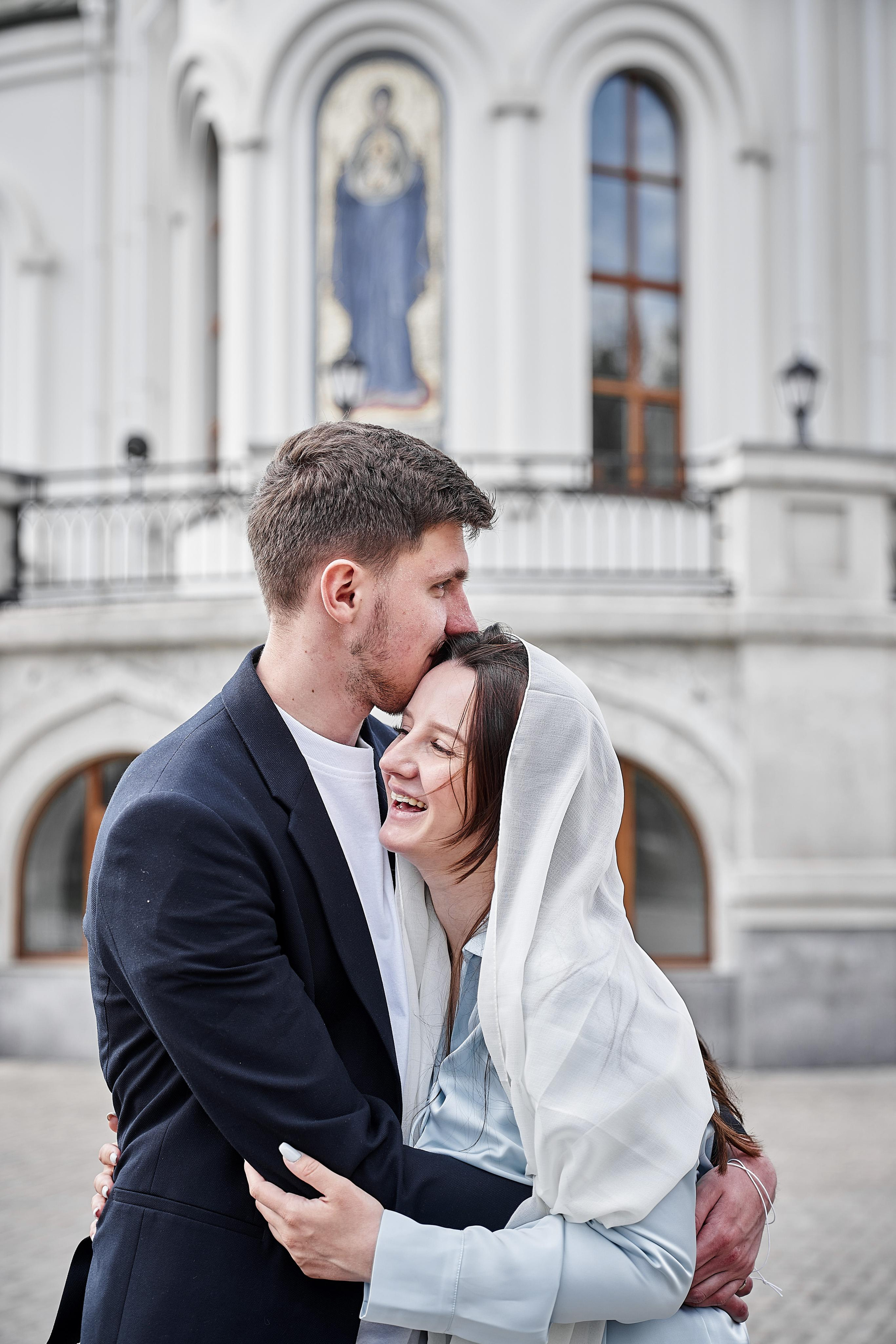 смех, объятия мужа и жены у Храма Сергия Радонежского в Солнцево