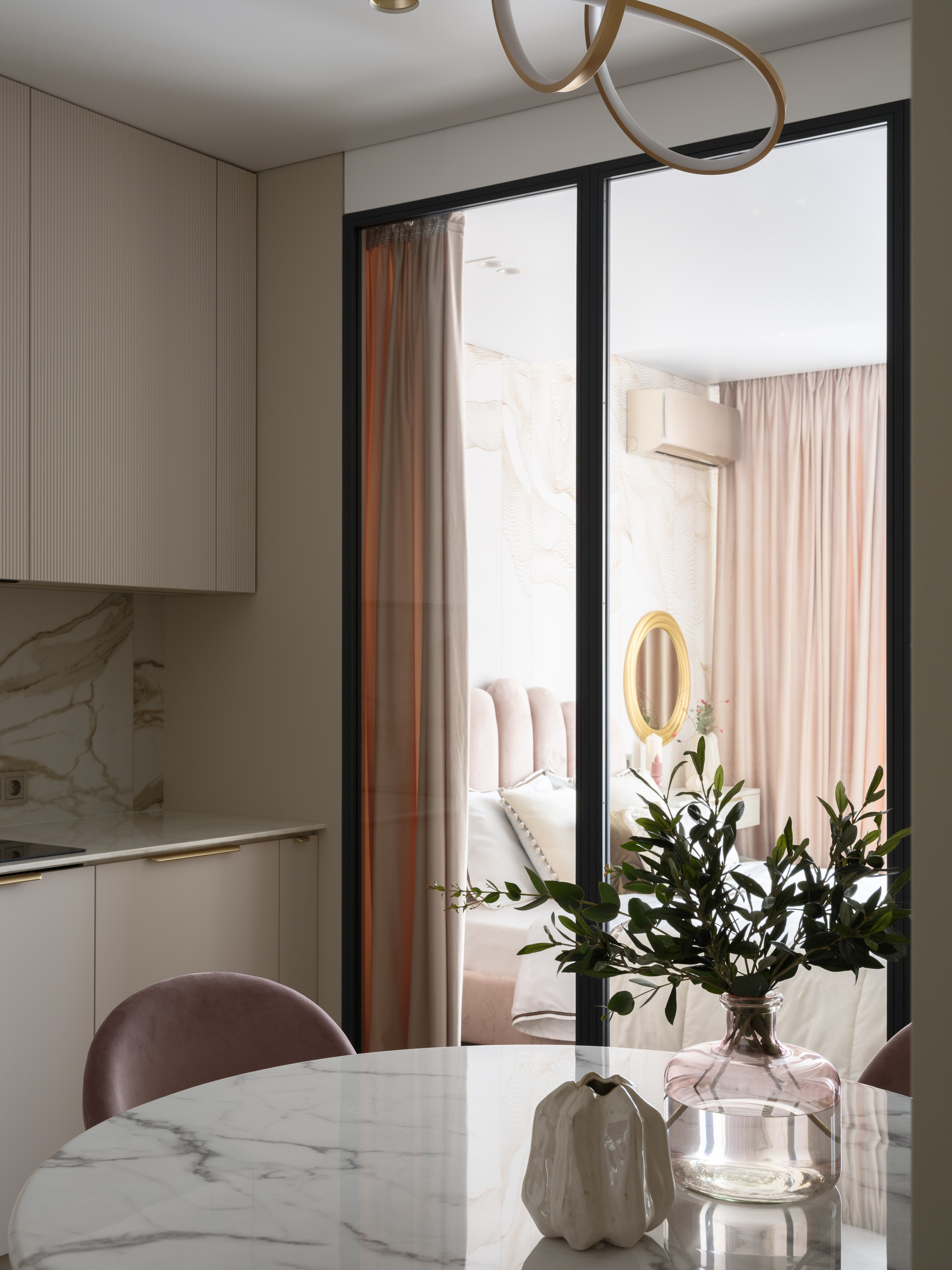 Современная кухня с мраморным столом и декоративной вазой, открывающая вид на спальню за стеклянной перегородкой. Интерьер спроектирован Любовью Колосковой, фото Сергея Денисенко.