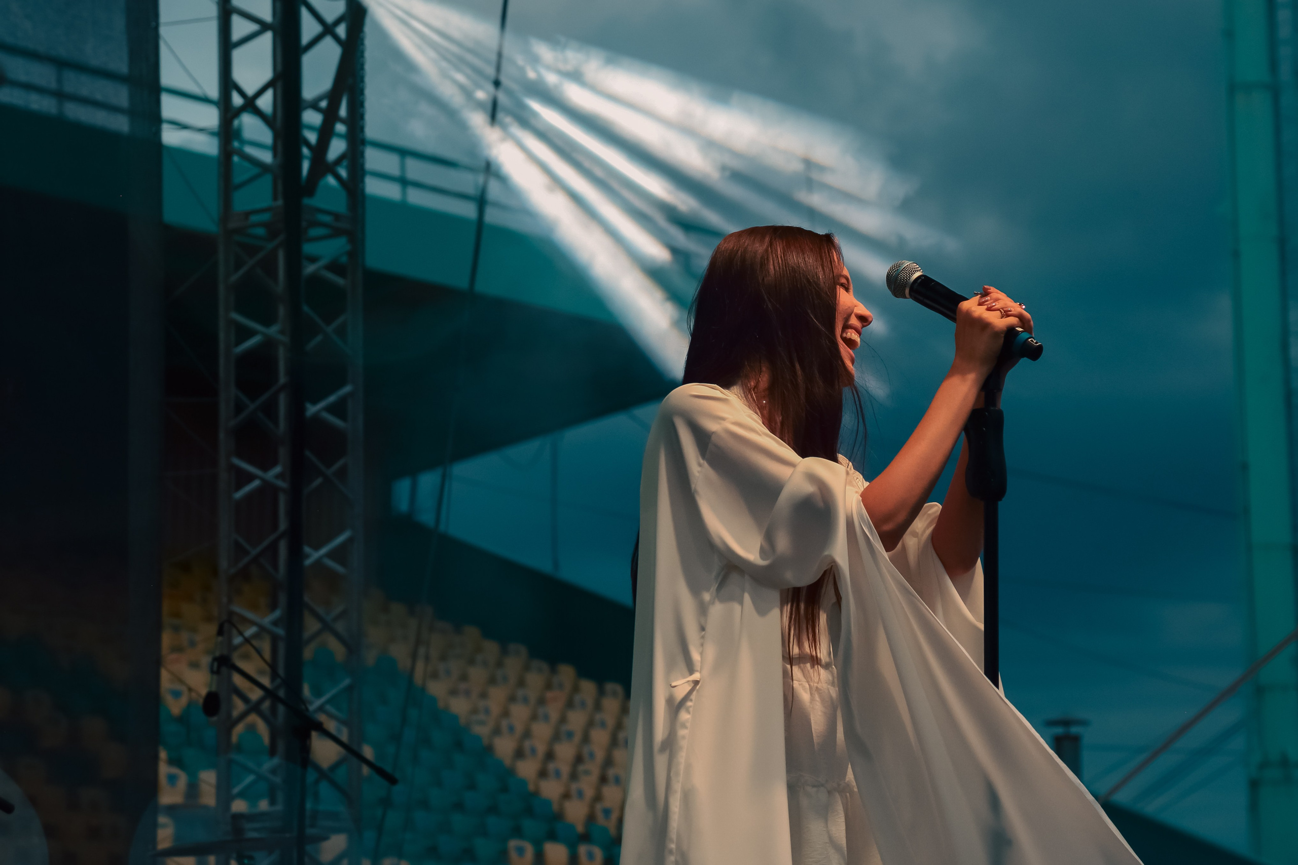 Концертная фотосессия для артиста: портрет со сцены на фоне вечернего неба Липецка.