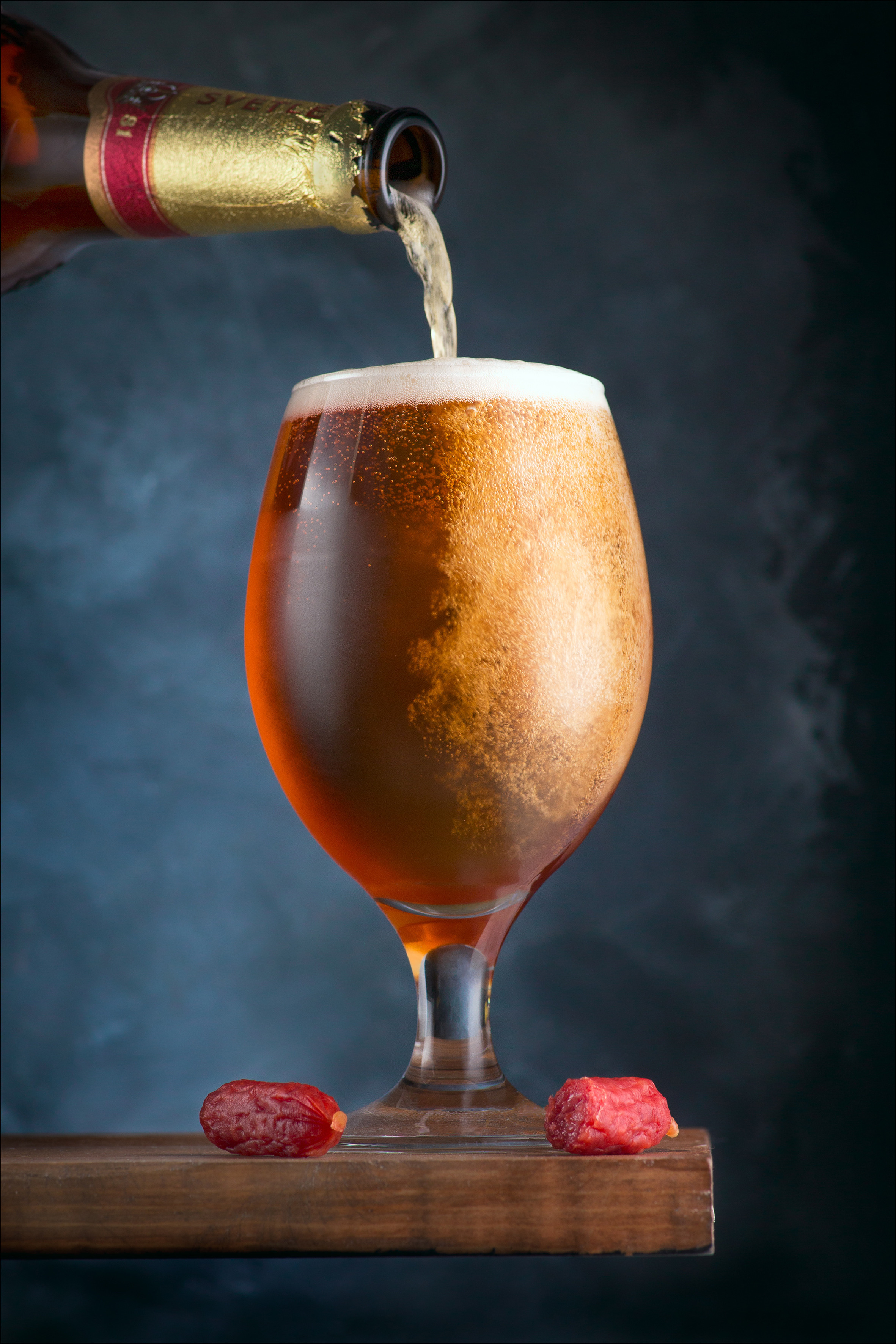 Наливание пенного пива в стеклянный бокал в баре