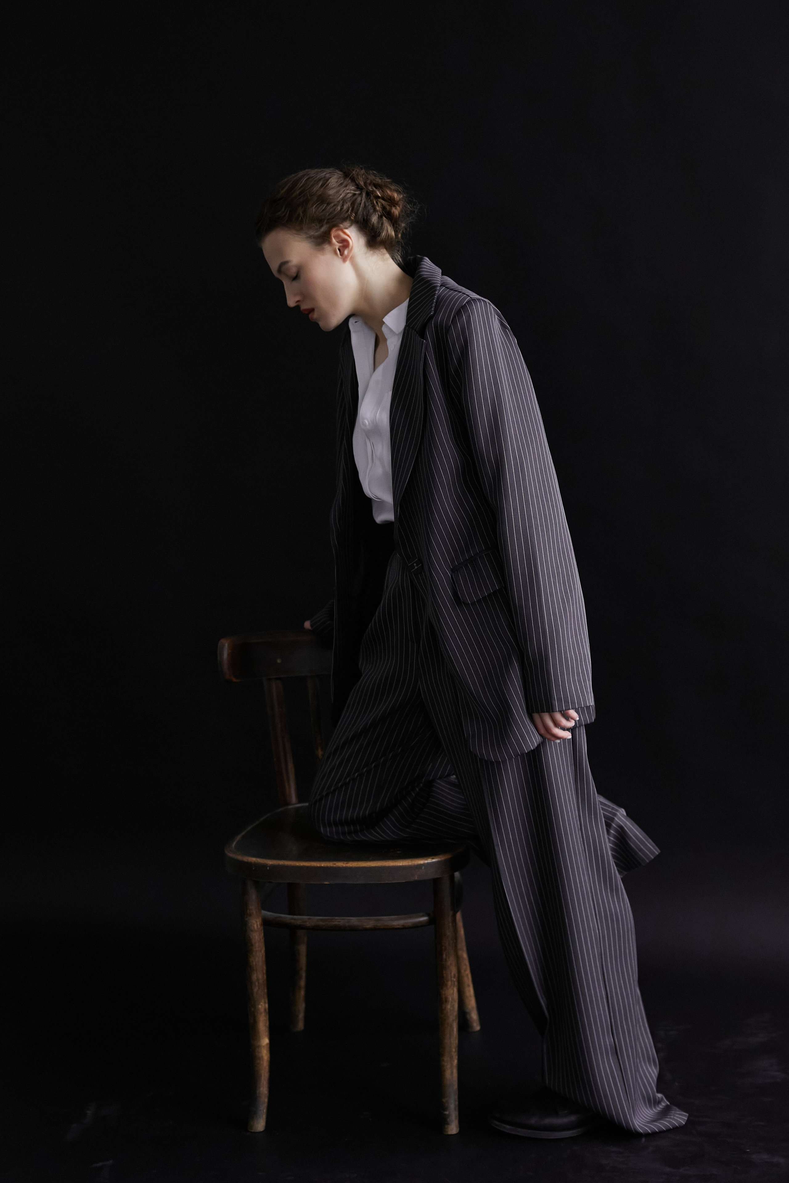 Фотограф в Москве. Студия. Студийный портрет. Девушка в пиджаке. Девушка на стуле на черном фоне. Красивая девушка в мужском костюме. Женский портрет.