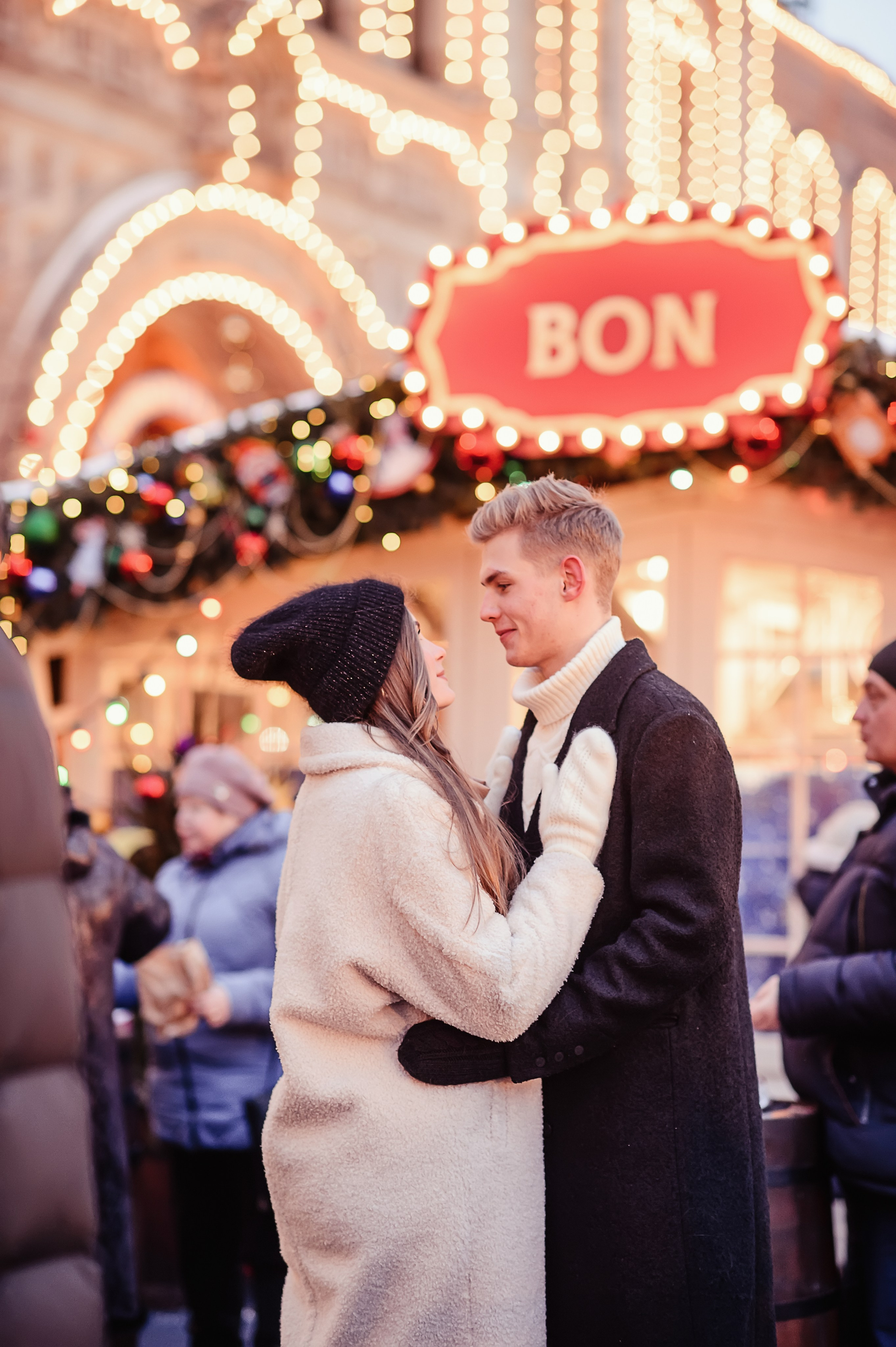 Фотография, на которой изображена пара влюбленных молодых людей, которые стоят, в обнимку  и смотрят друг другу в глаза на фоне ГУМа на Красной площади в Москве