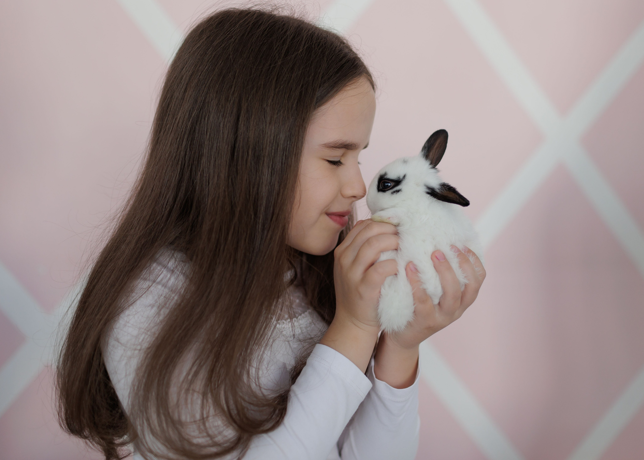 Девочка целует белого кролика