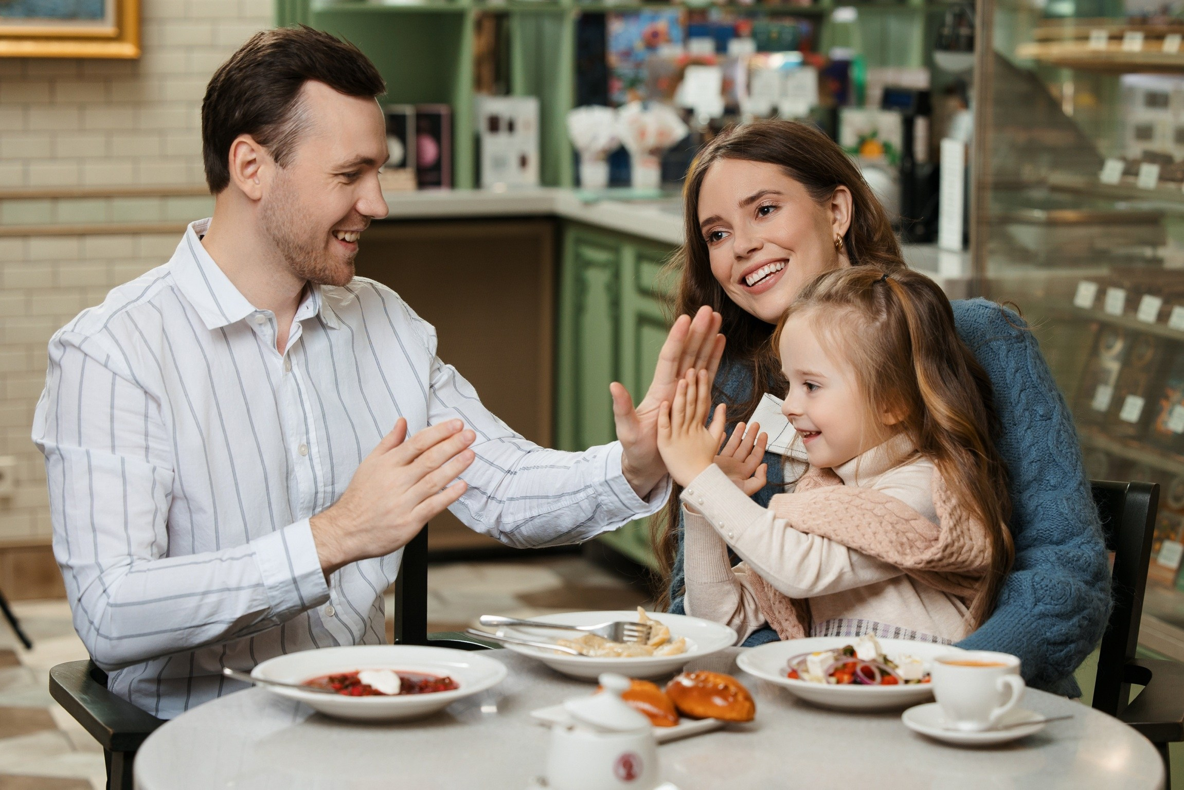 Счастливая семья ест в ресторане