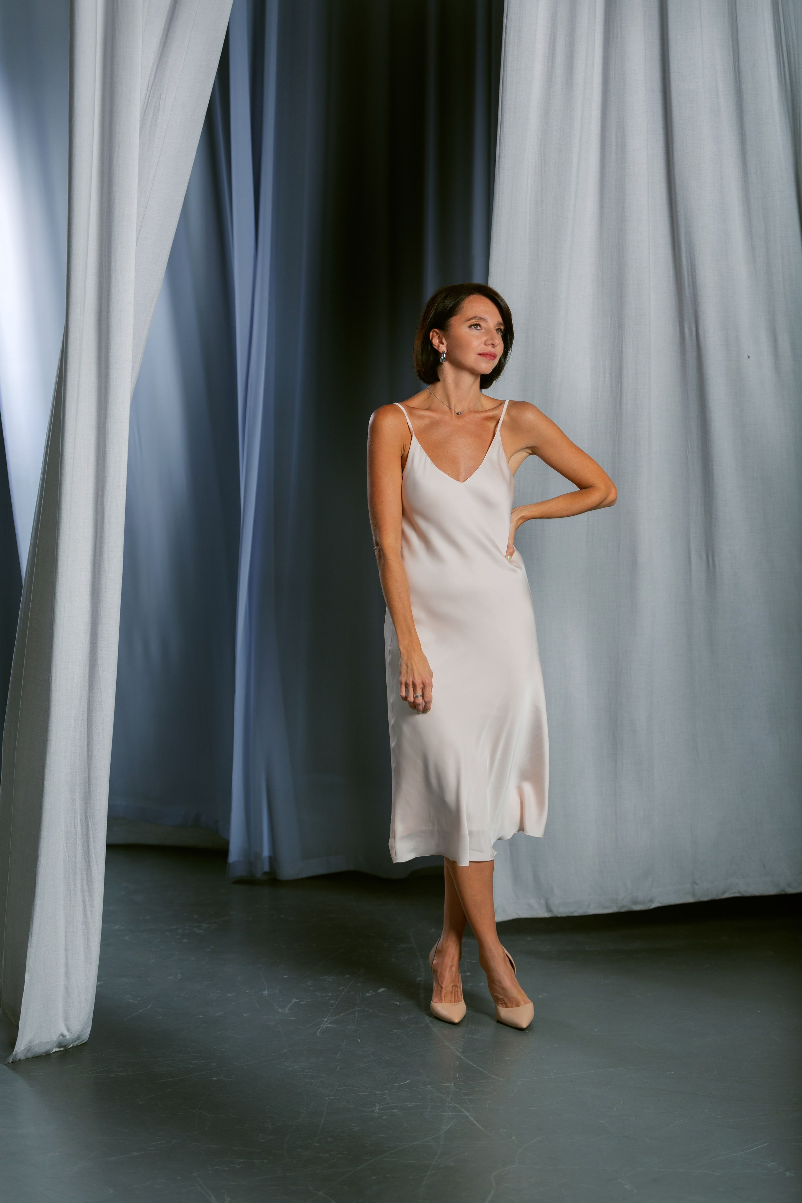 Портрет девушки у синих штор — фотосъёмка в студии с мягким светом.