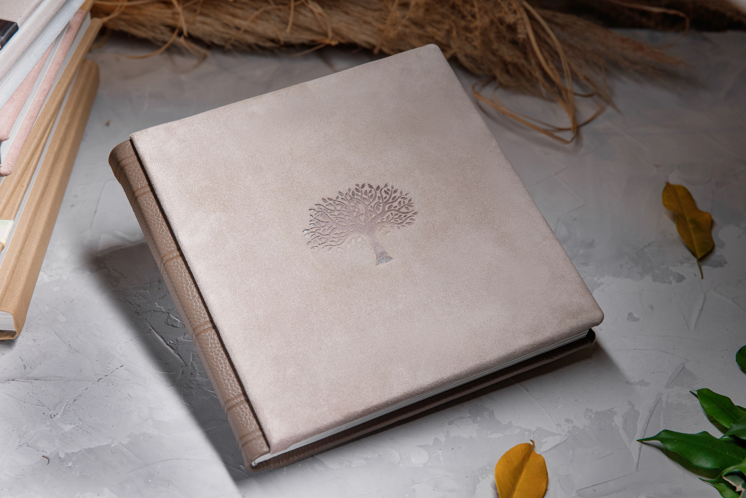Книга из замши и кожи с выдавленным деревом лежит на столе