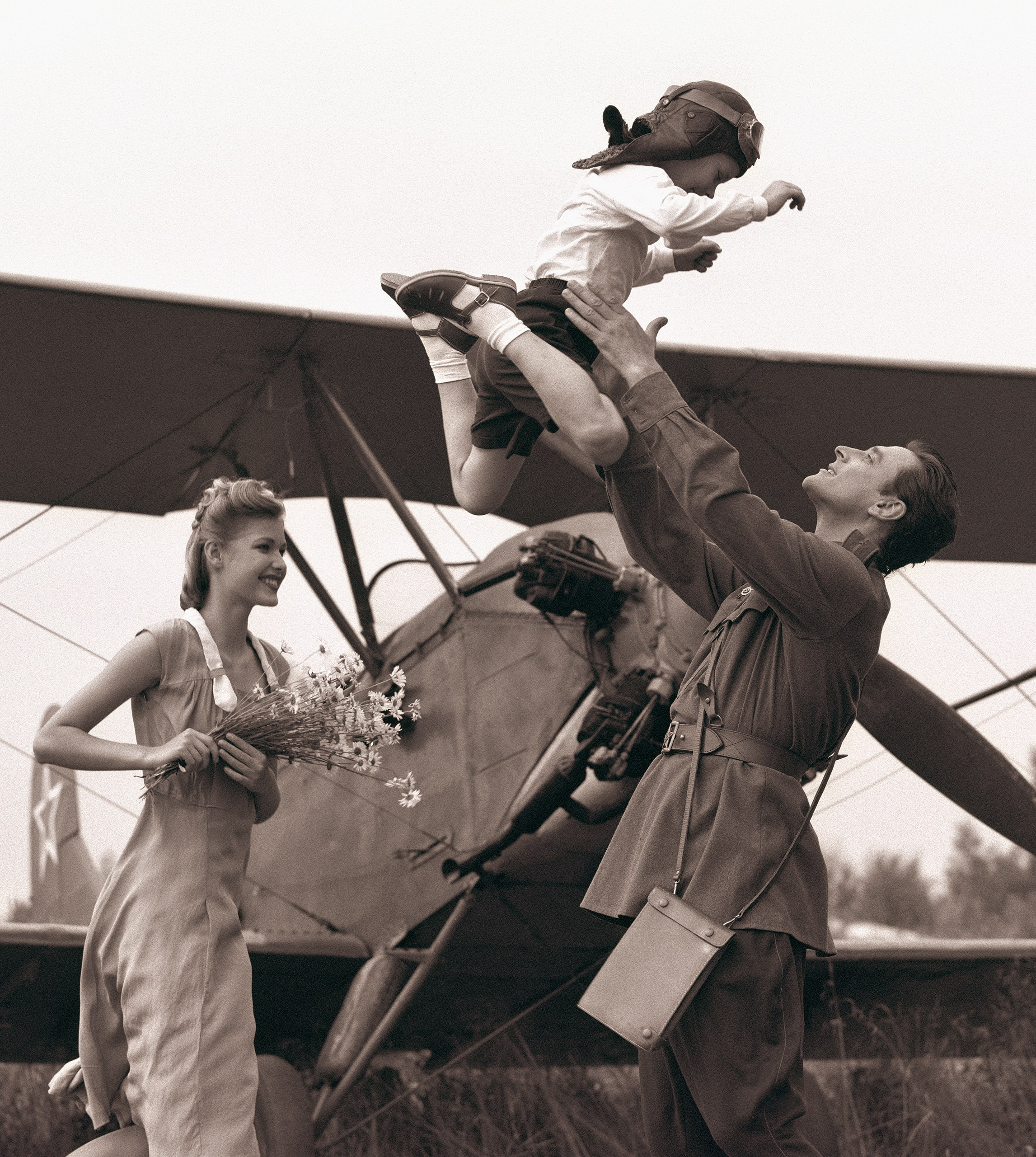 Семейная пара с ребенком на фоне самолета По-2