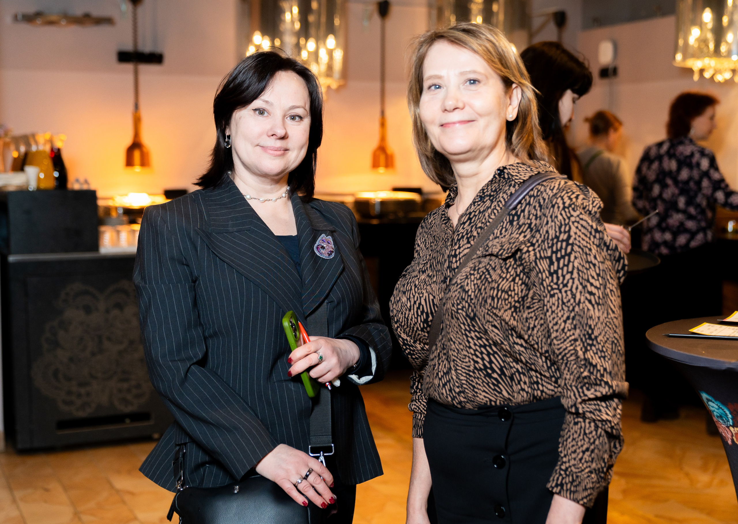 Две женщины в деловых костюмах позируют на корпоративном вечере в Radisson Sonya. Фото Евгения Мальцева.