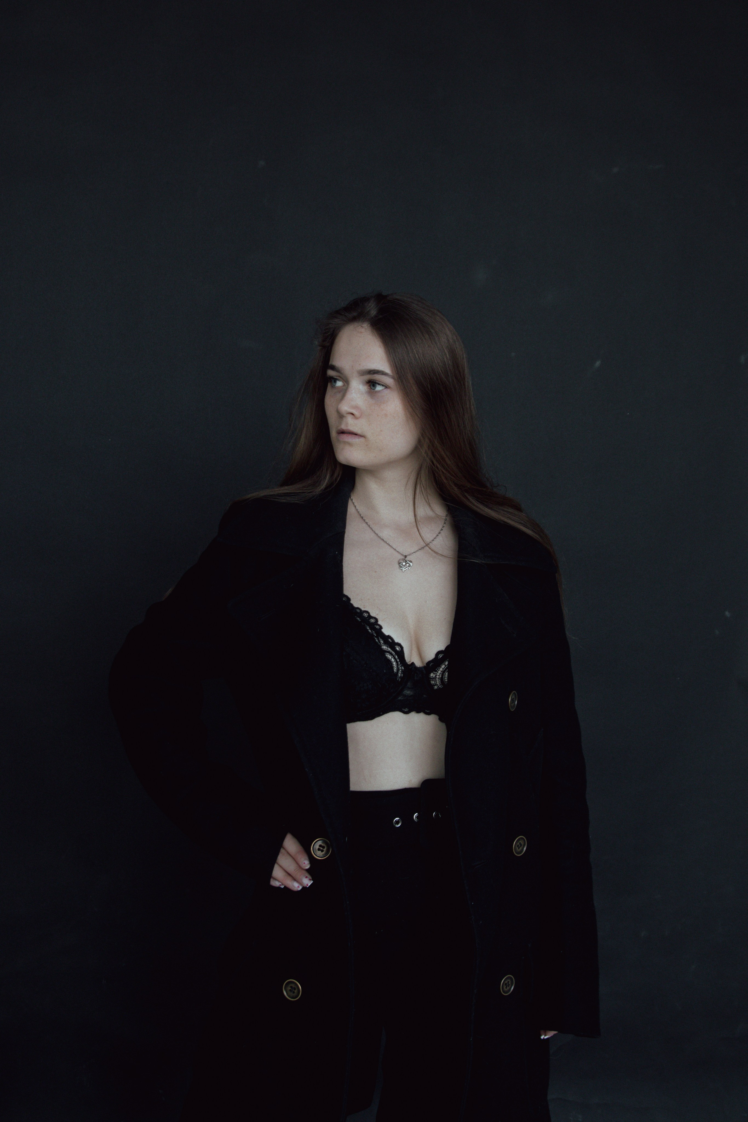 Фотосессия в белье и пальто на черном фоне с распущенными волосами фото в цвете