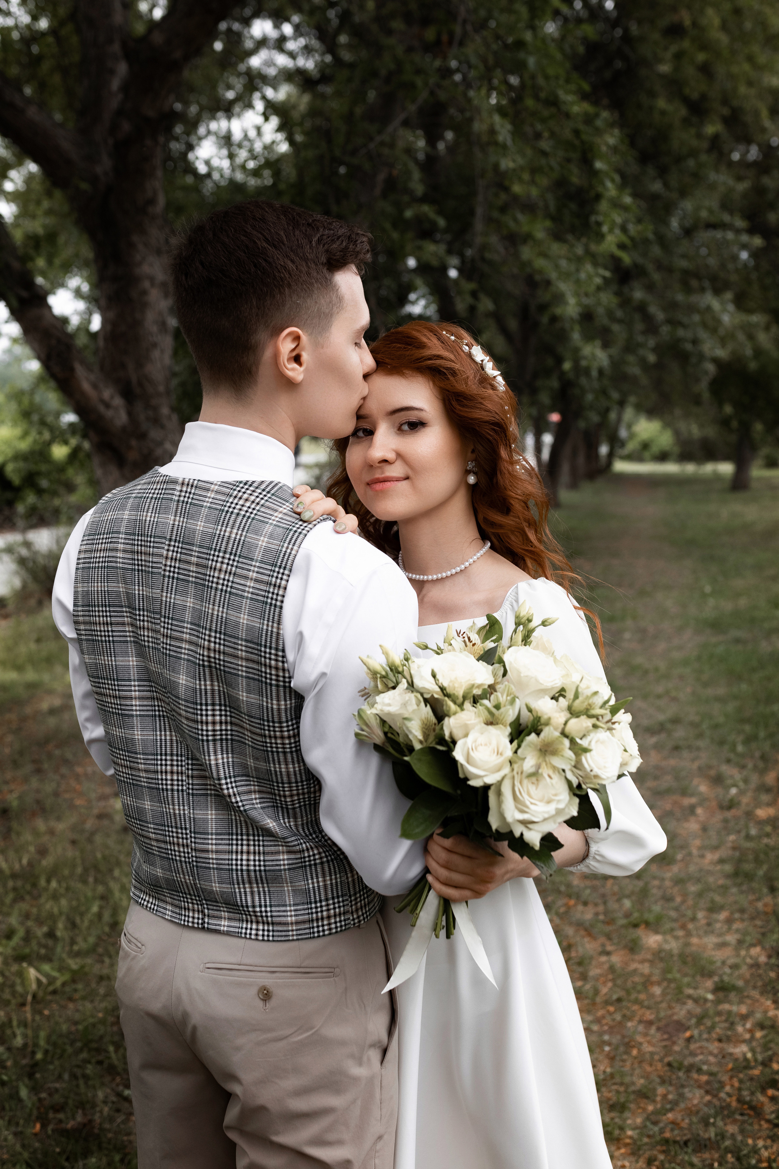 жених и невеста бегут по яблоневой аллее