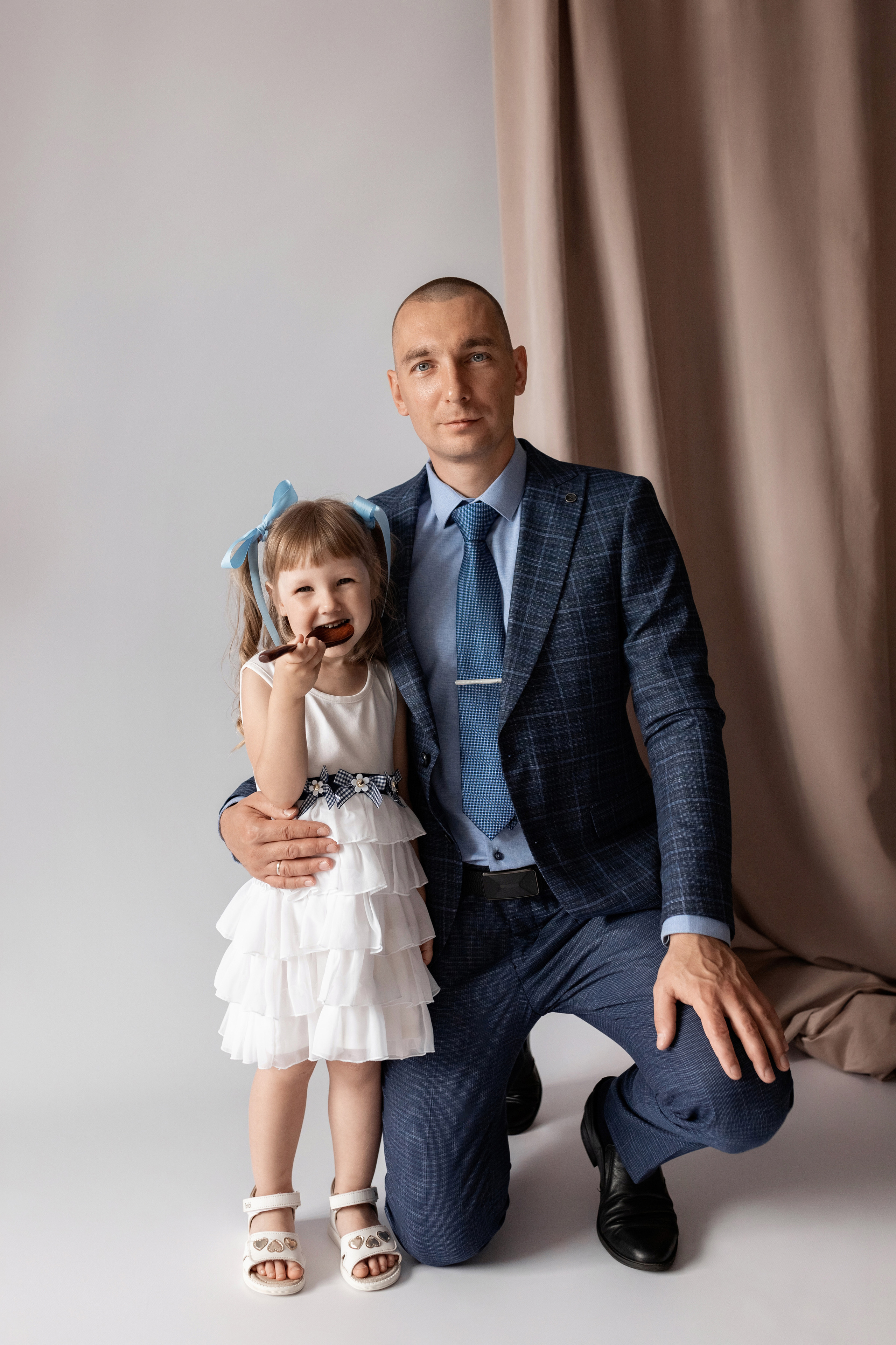 Индивидуальная мужская фотосессия в студии минимализм. на стуле. на белом фоне, на бежевом фоне. В классическом костюме тройка. С дочкой.