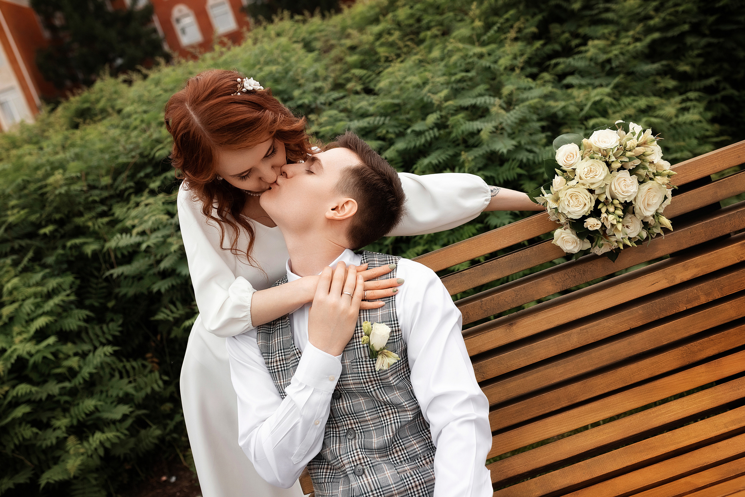 жених позирует с невестой на лавочке в парке