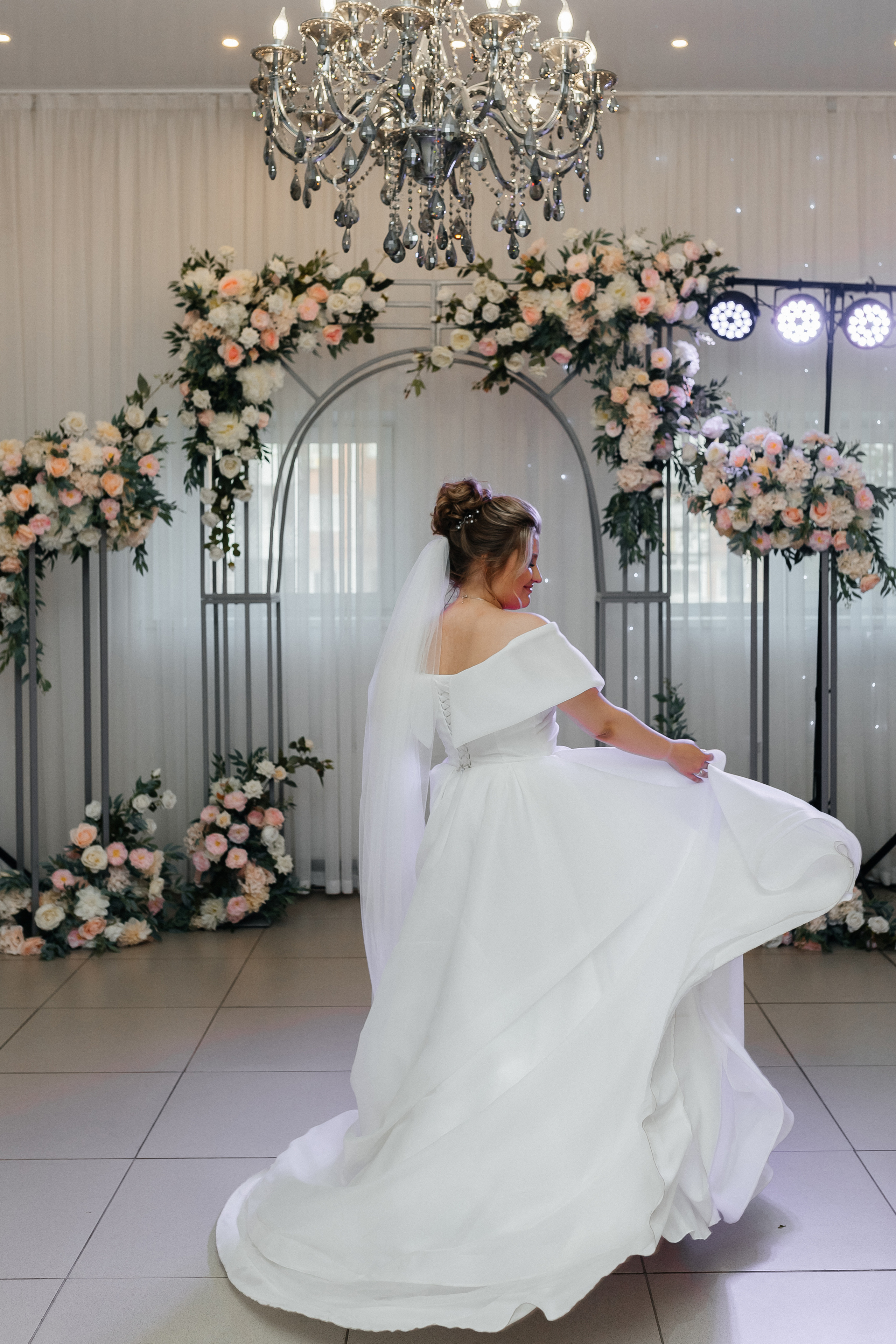 Невеста кружится в белом платье, играет подолом