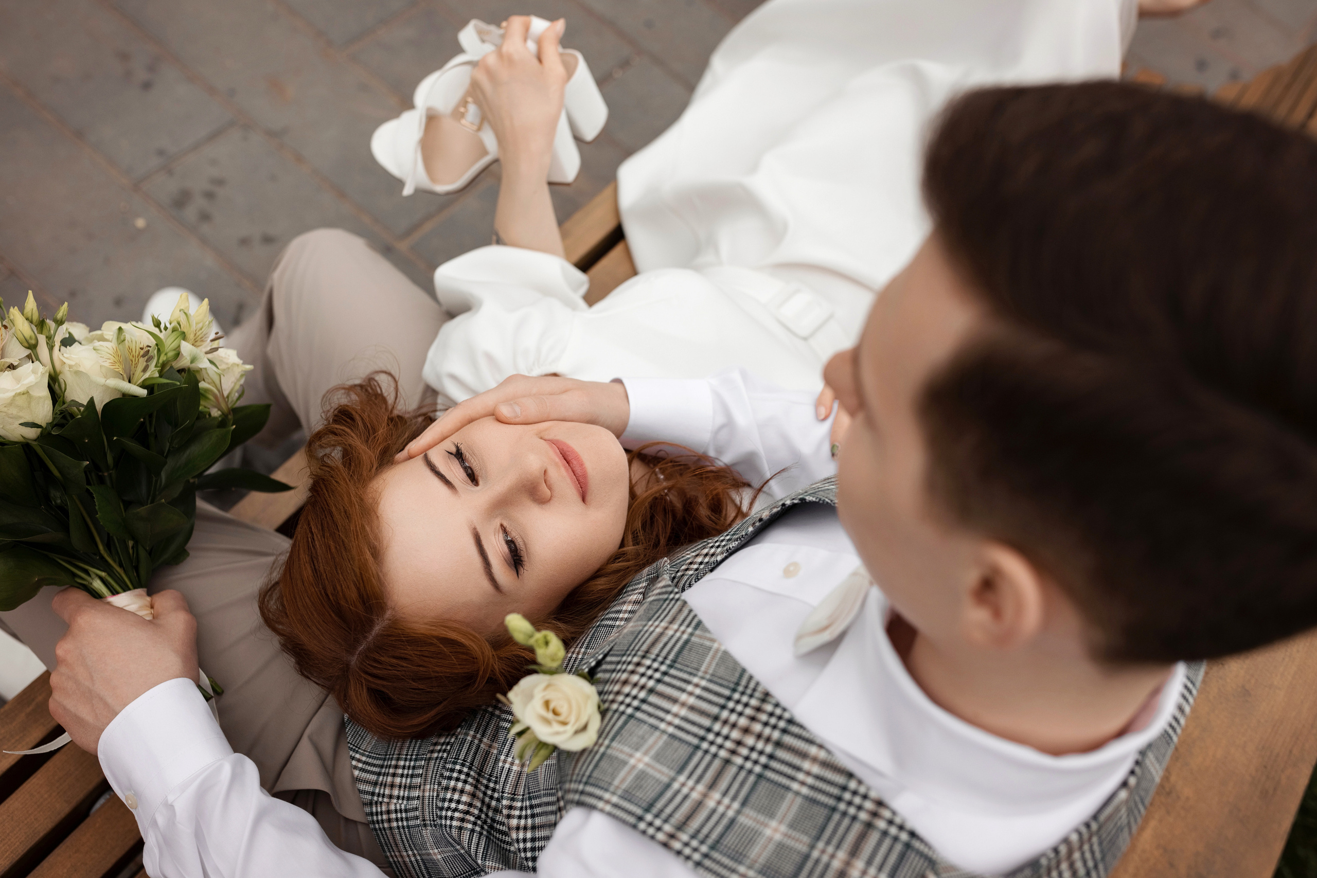 жених позирует с невестой на лавочке в парке