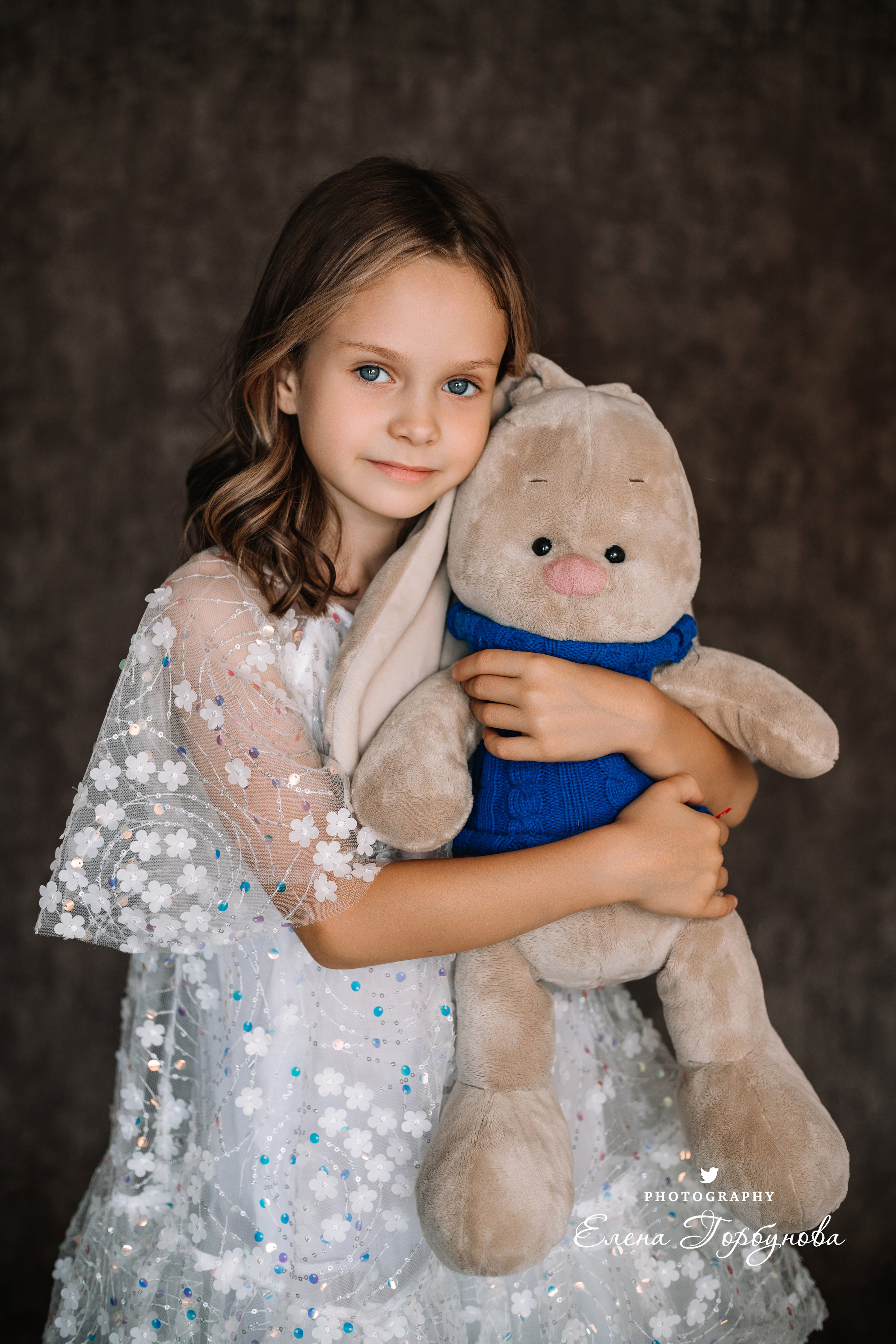 Фотосессия в садике Пермь фотограф Елена Гобунова Девочка в белом платье позирует на стуле с цветами Открытка для мамы. Детская фотосессия. Детский портрет в студии