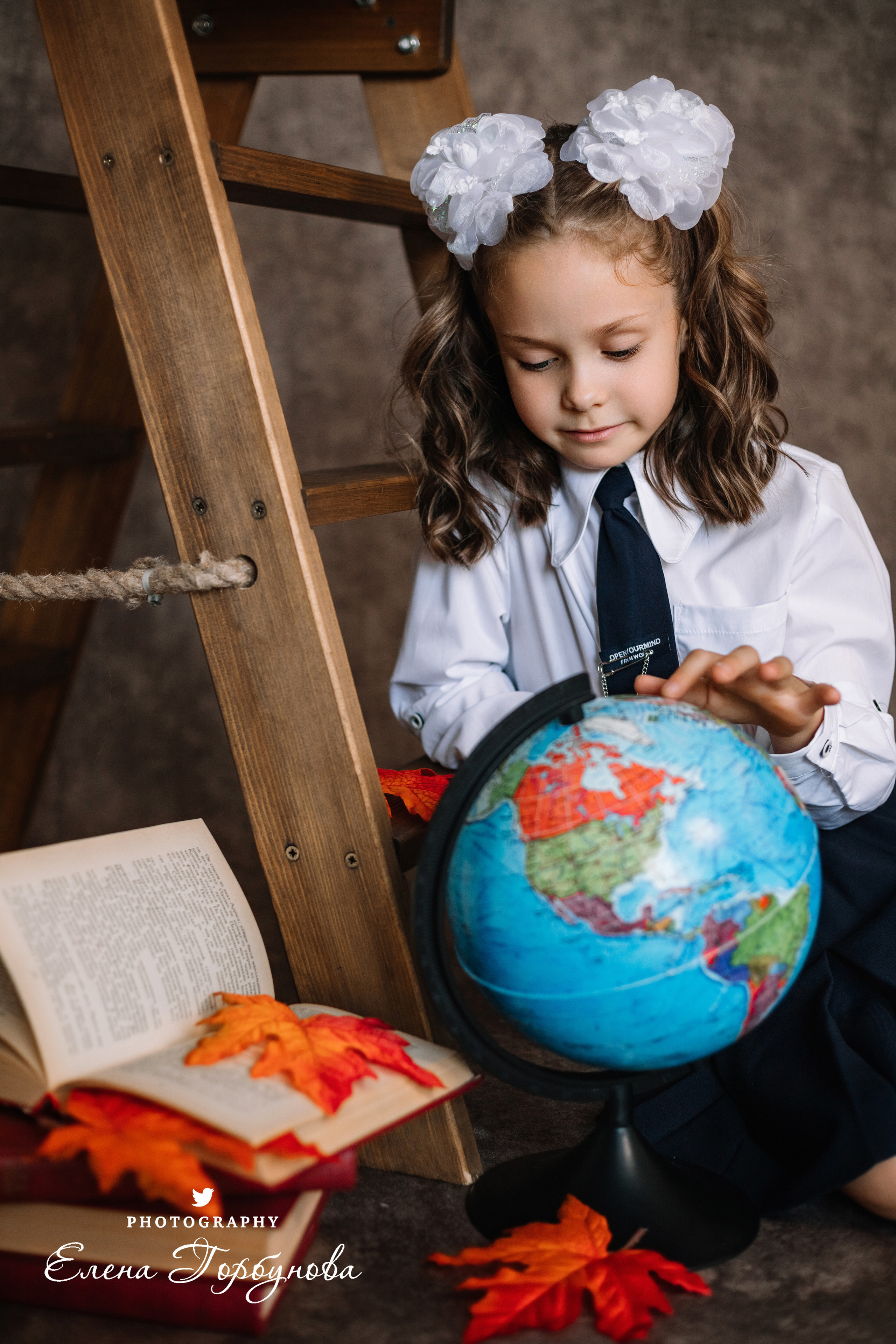 Фотограф Елена Горбунова Пермь. школьный портрет. фотосессия на 1 сентября. девочка в школьной форме с глобусом и книжками, с осенними листьями. Листья клена на портрете. школьный портрет в студии на фото. художественный портрет. школьный фотограф.