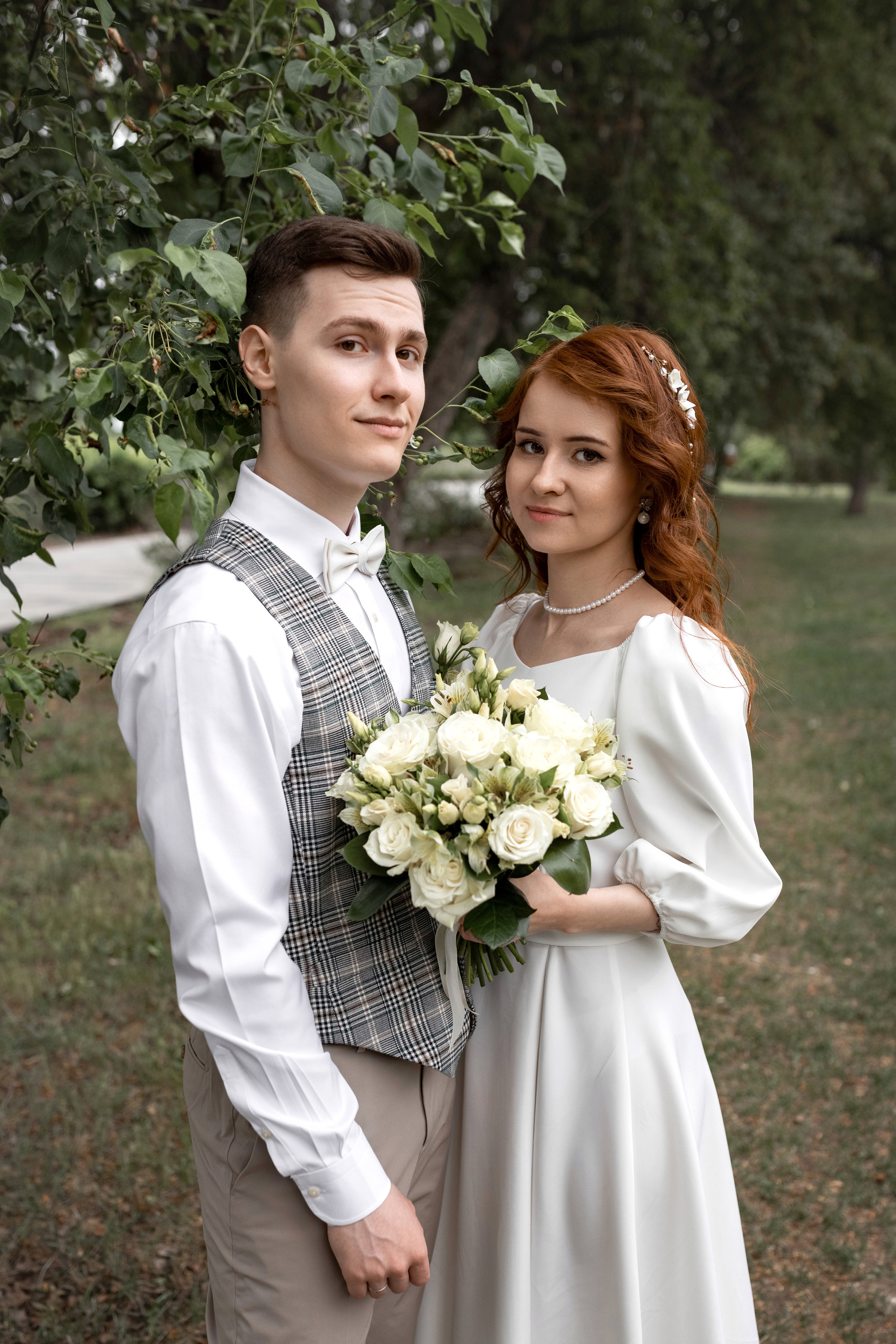 жених и невеста бегут по яблоневой аллее