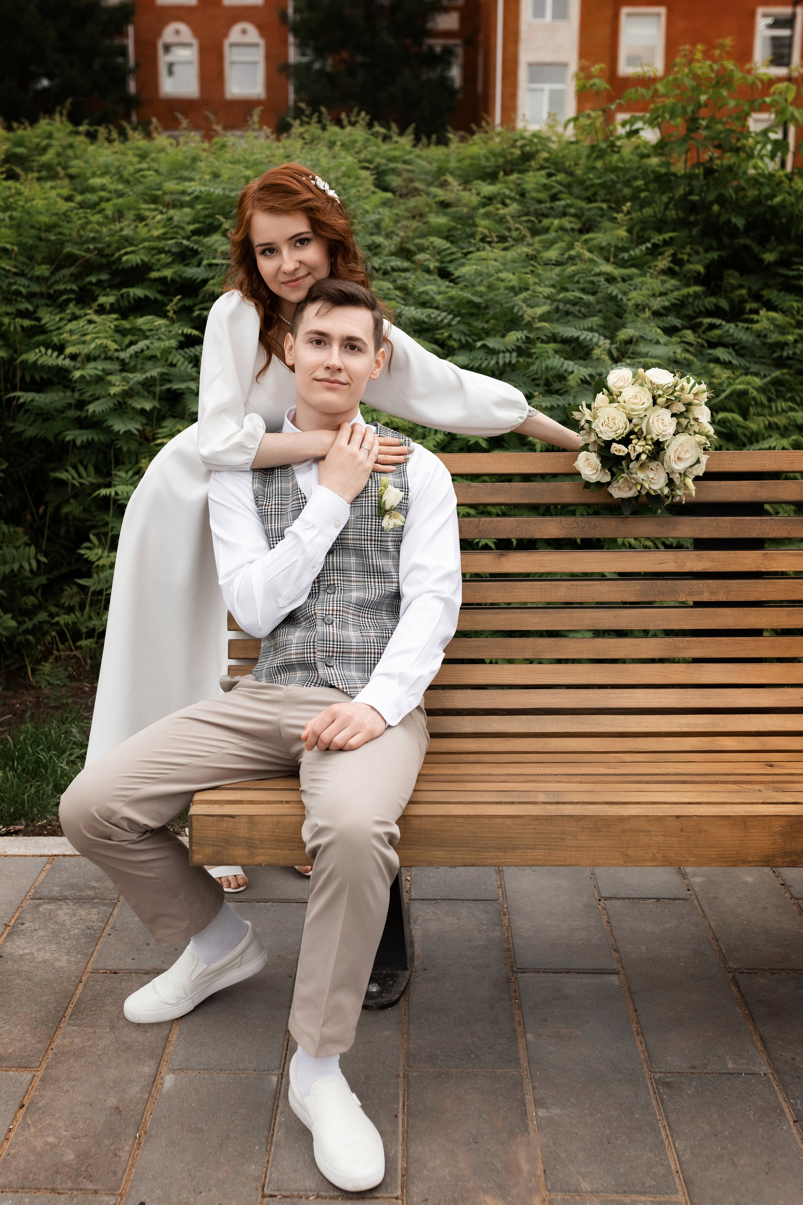 жених позирует с невестой на лавочке в парке