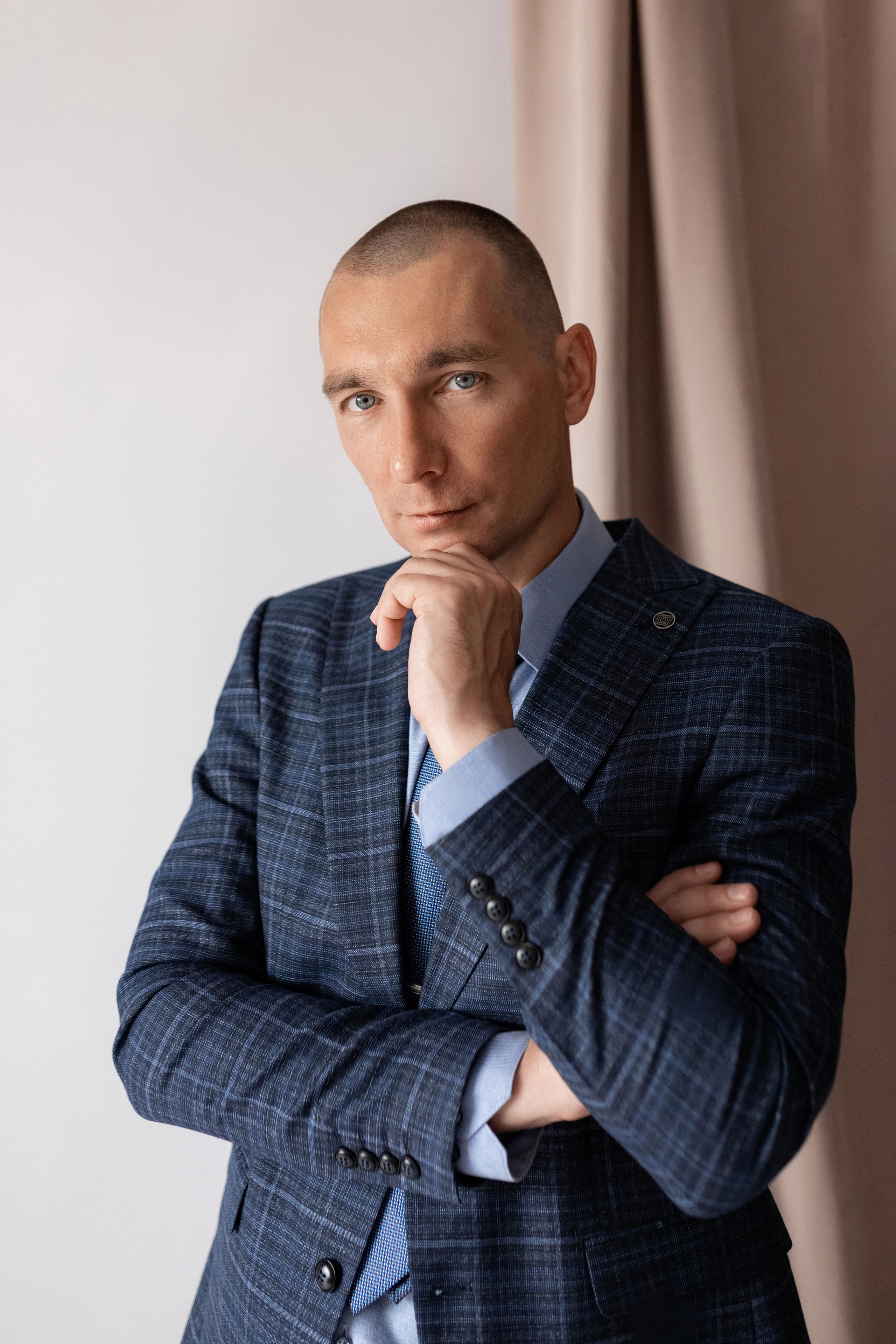 Индивидуальная мужская фотосессия в студии минимализм. на стуле. на белом фоне, на бежевом фоне. В классическом костюме тройка