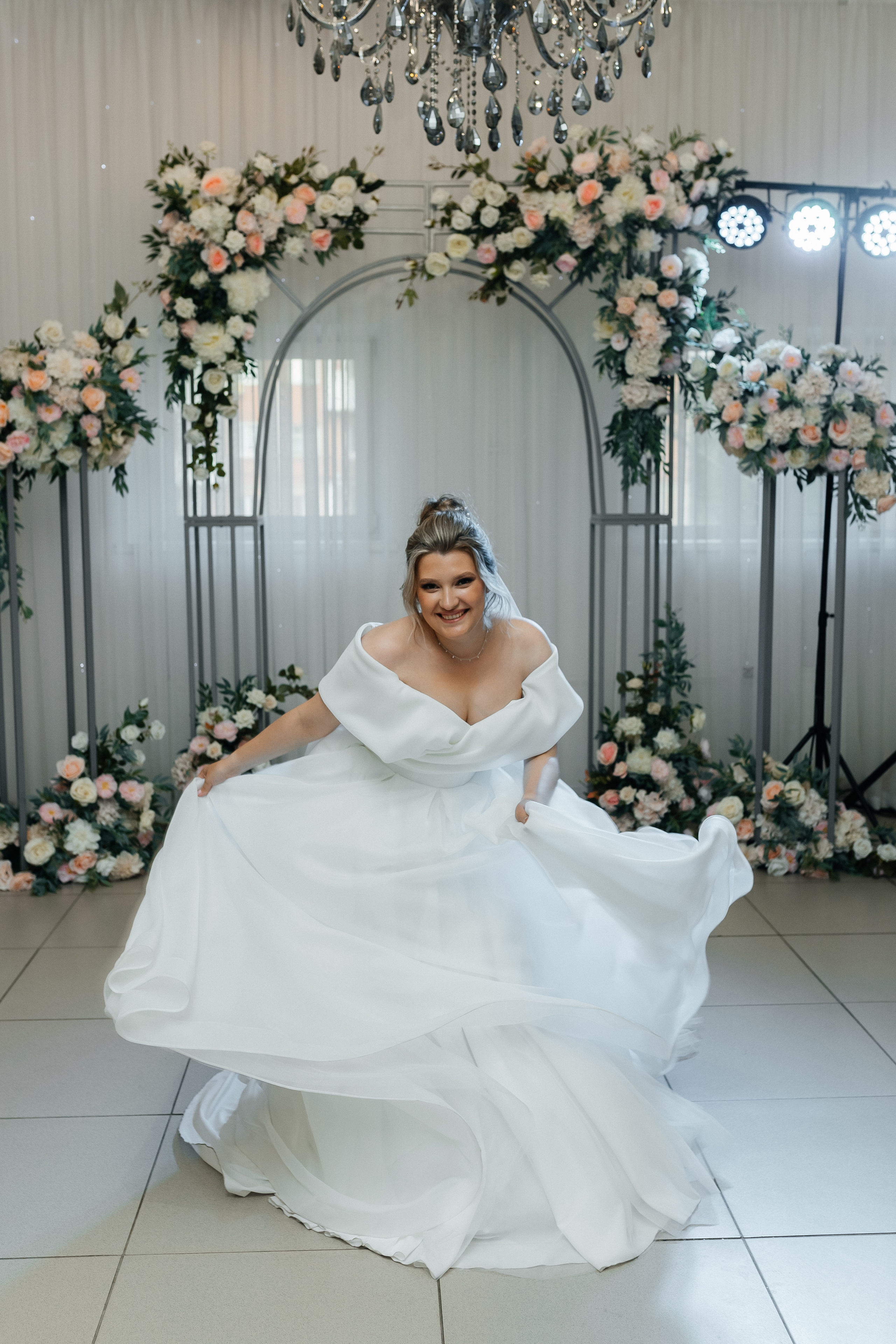 Невеста кружится в белом платье, играет подолом