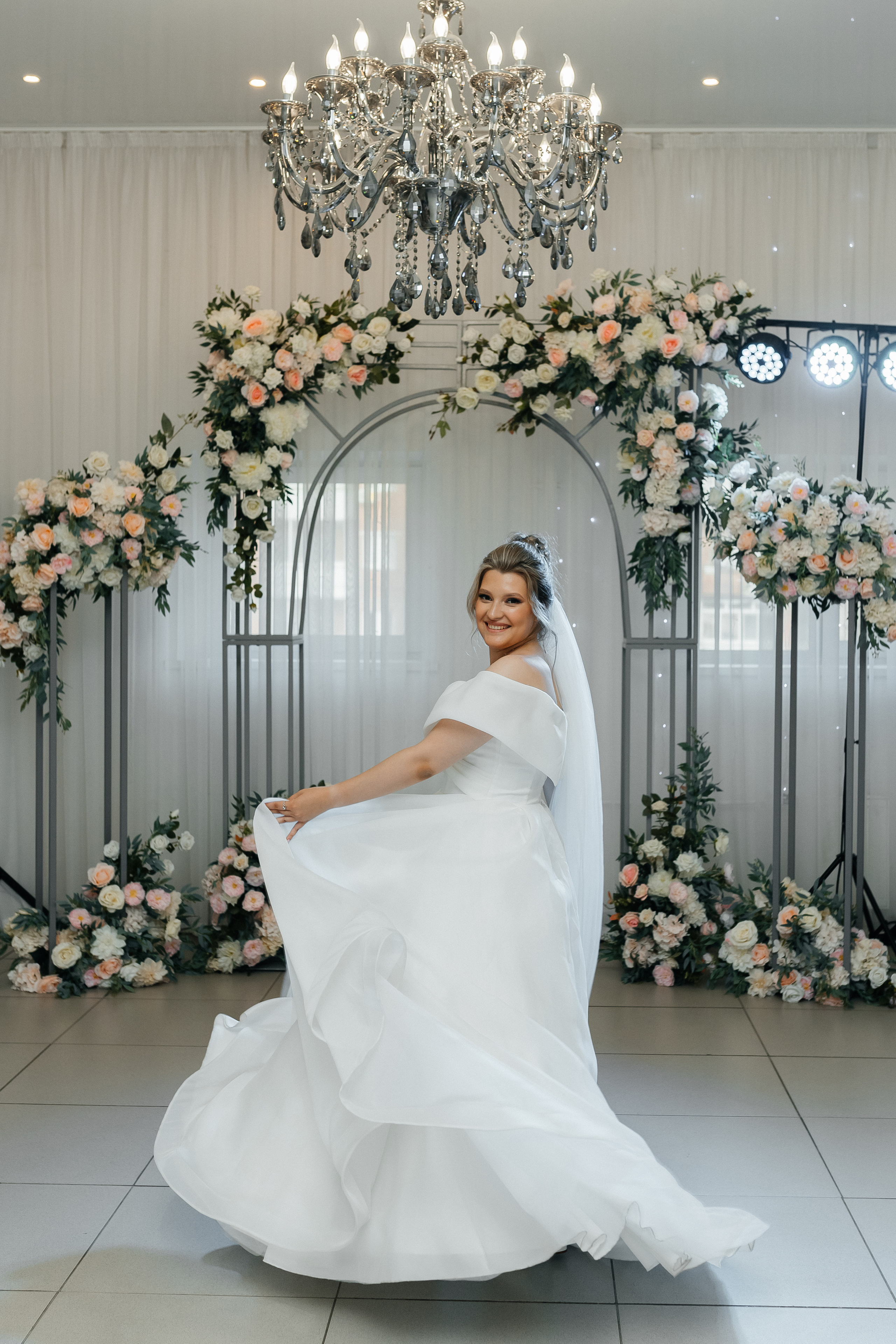 Невеста кружится в белом платье, играет подолом