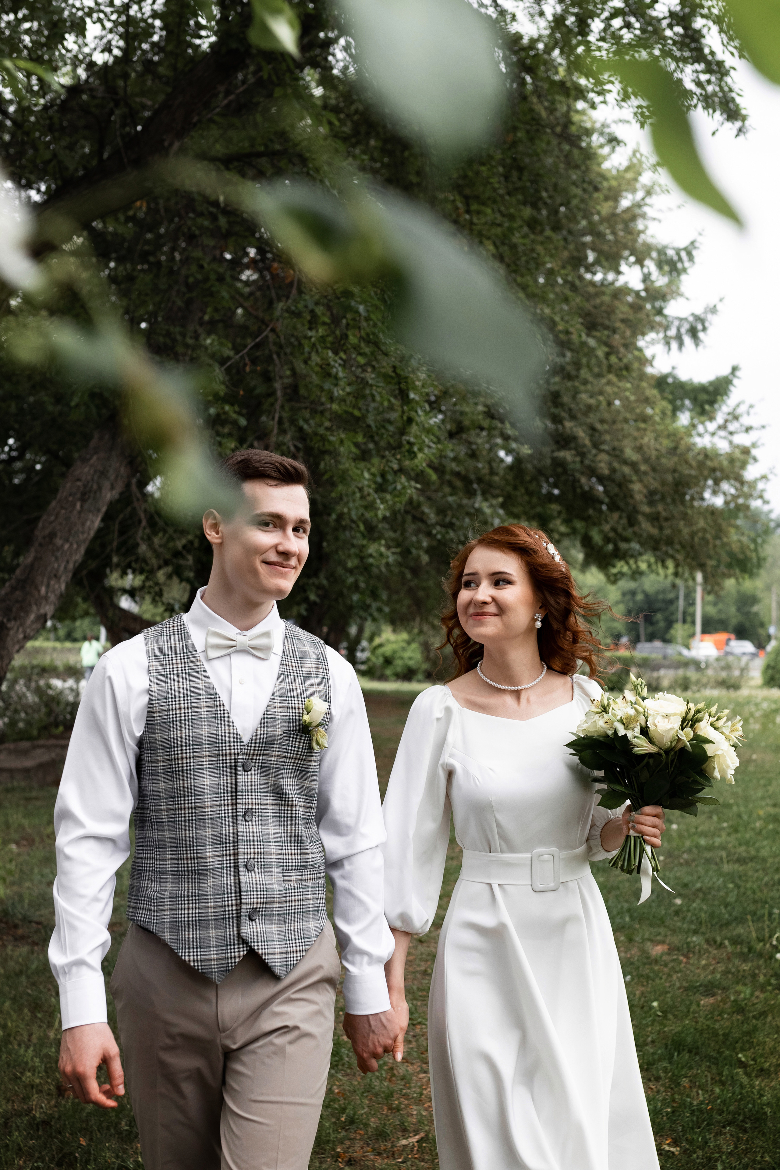 жених и невеста бегут по яблоневой аллее